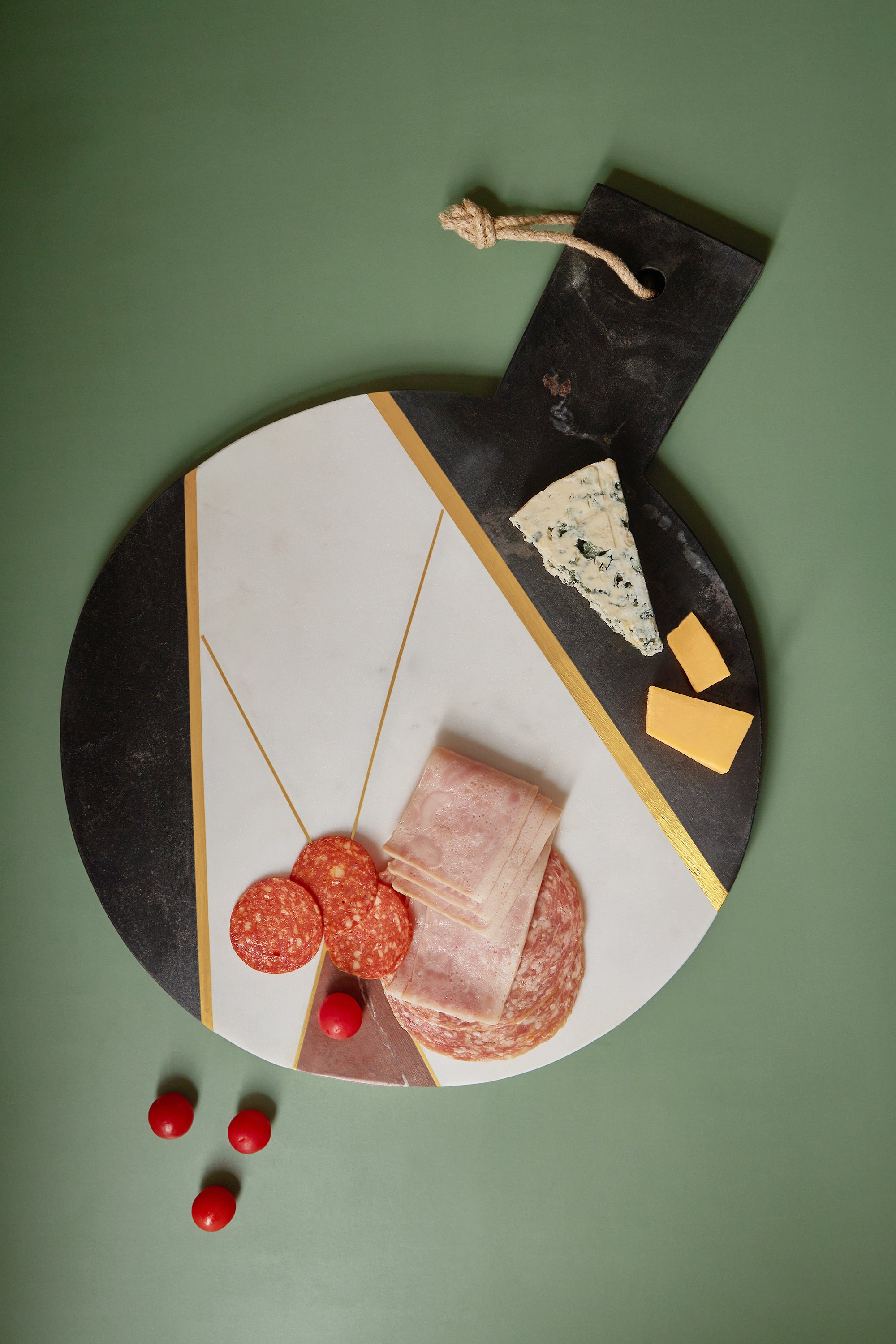 Large marble charcuterie board featuring natural multi-tone marble and subtle brass inlay — refined entertaining accent