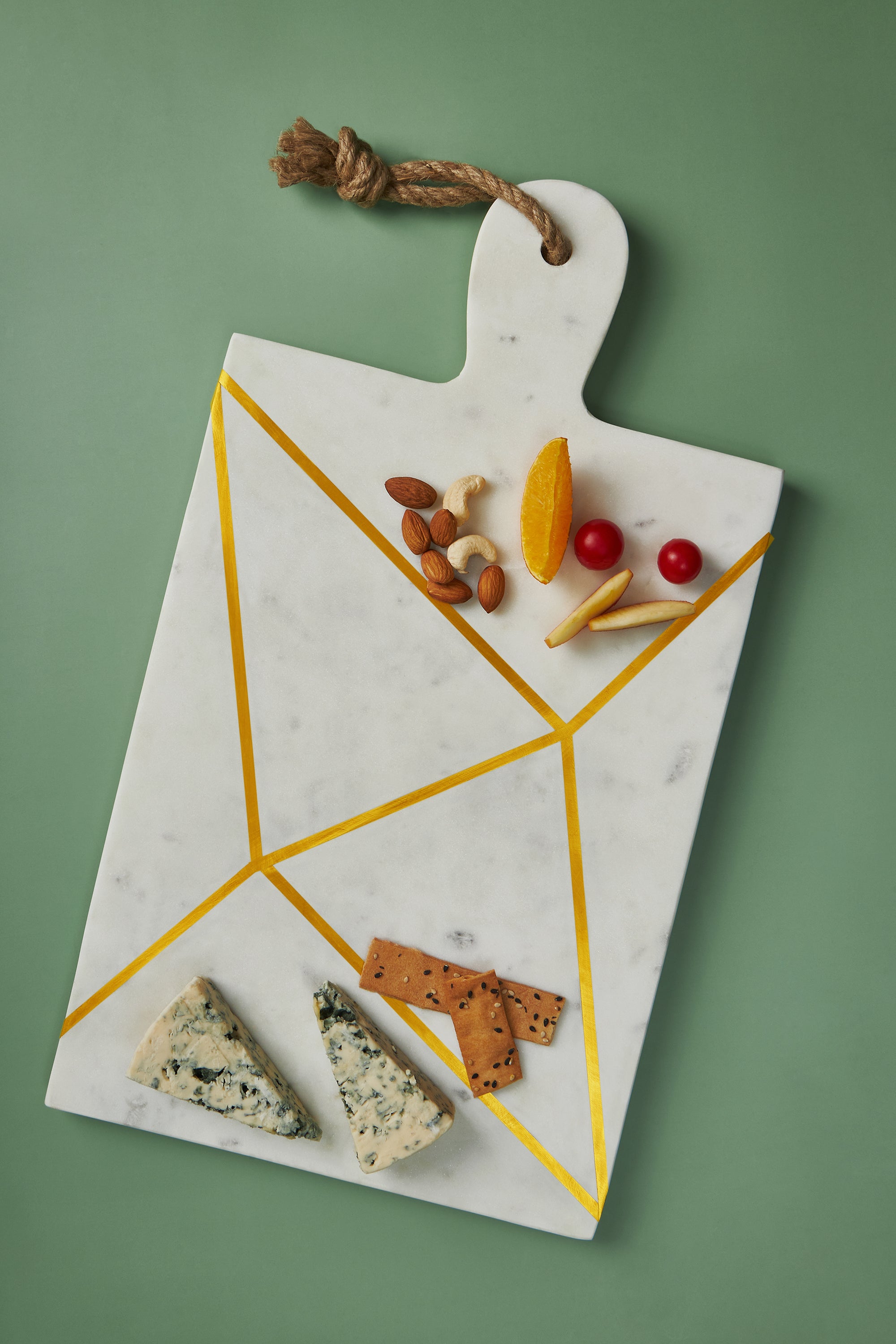 Large marble charcuterie board with polished brass detailing and smooth finish — refined home accent