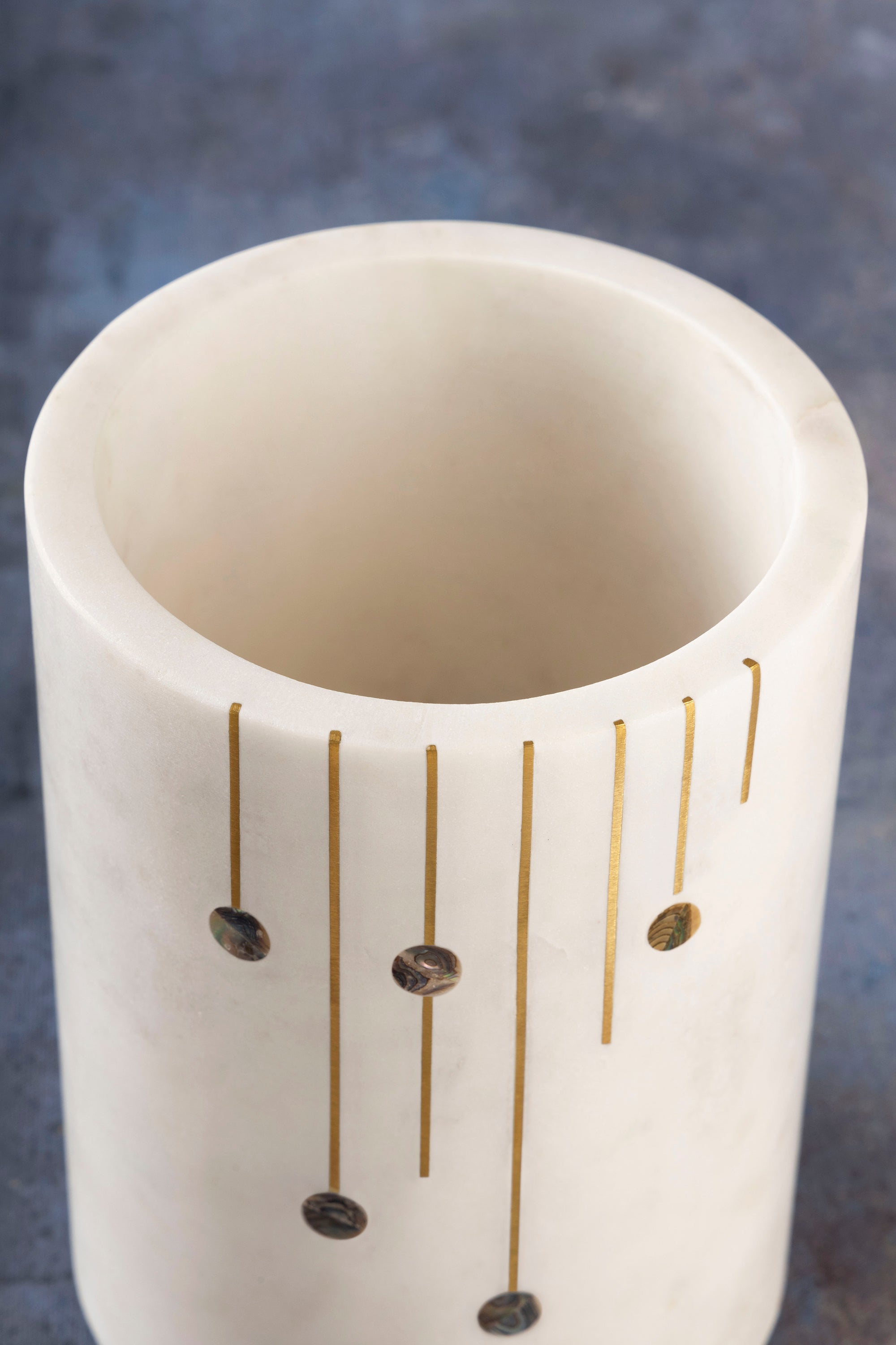 Artisan-made wine cooler in white stone featuring gold and pearl inlay — luxury home bar accessory