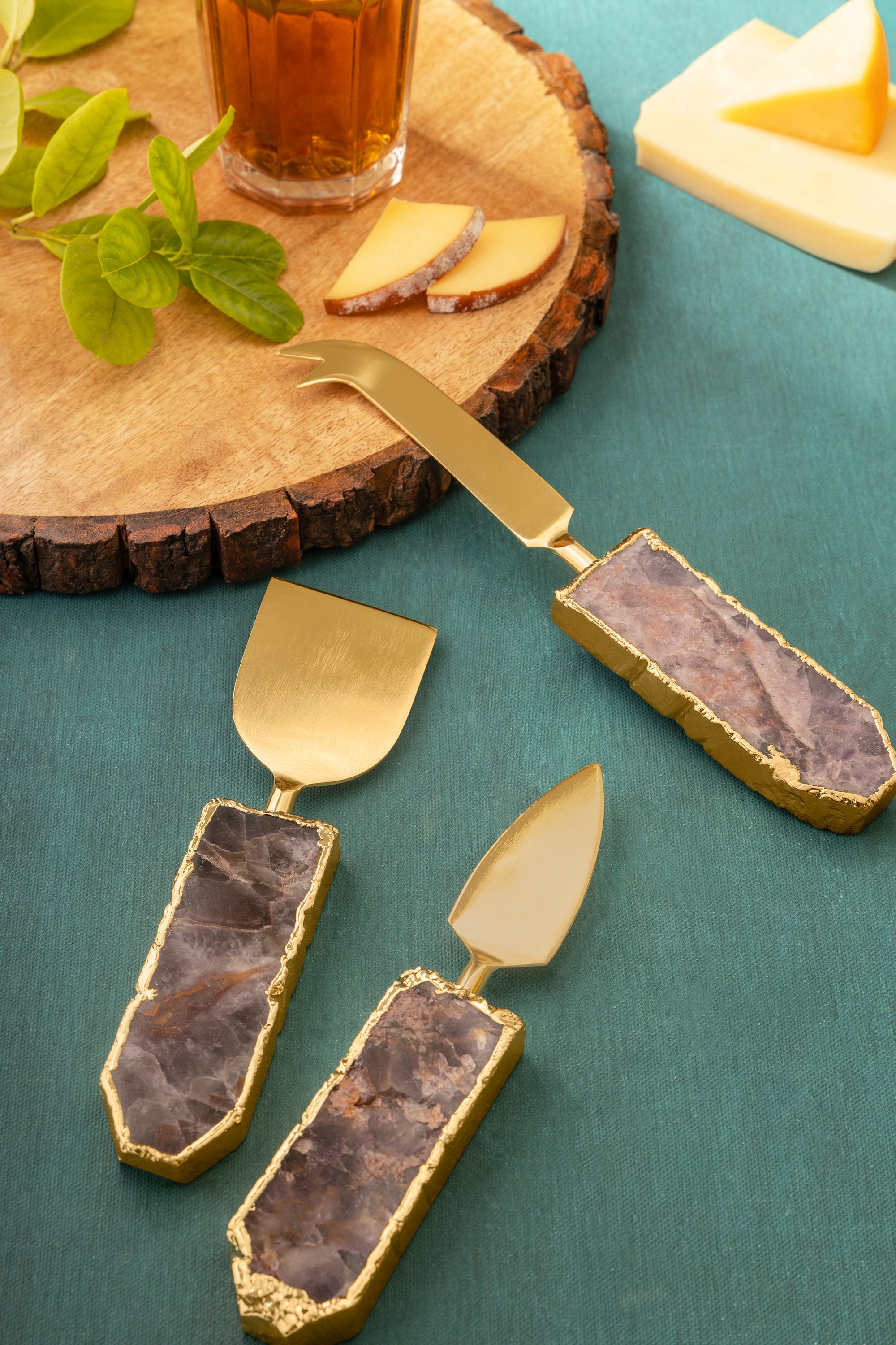 Handcrafted cheese knife set with semi-precious stone handles and gold-tone blades — artisan luxury accent