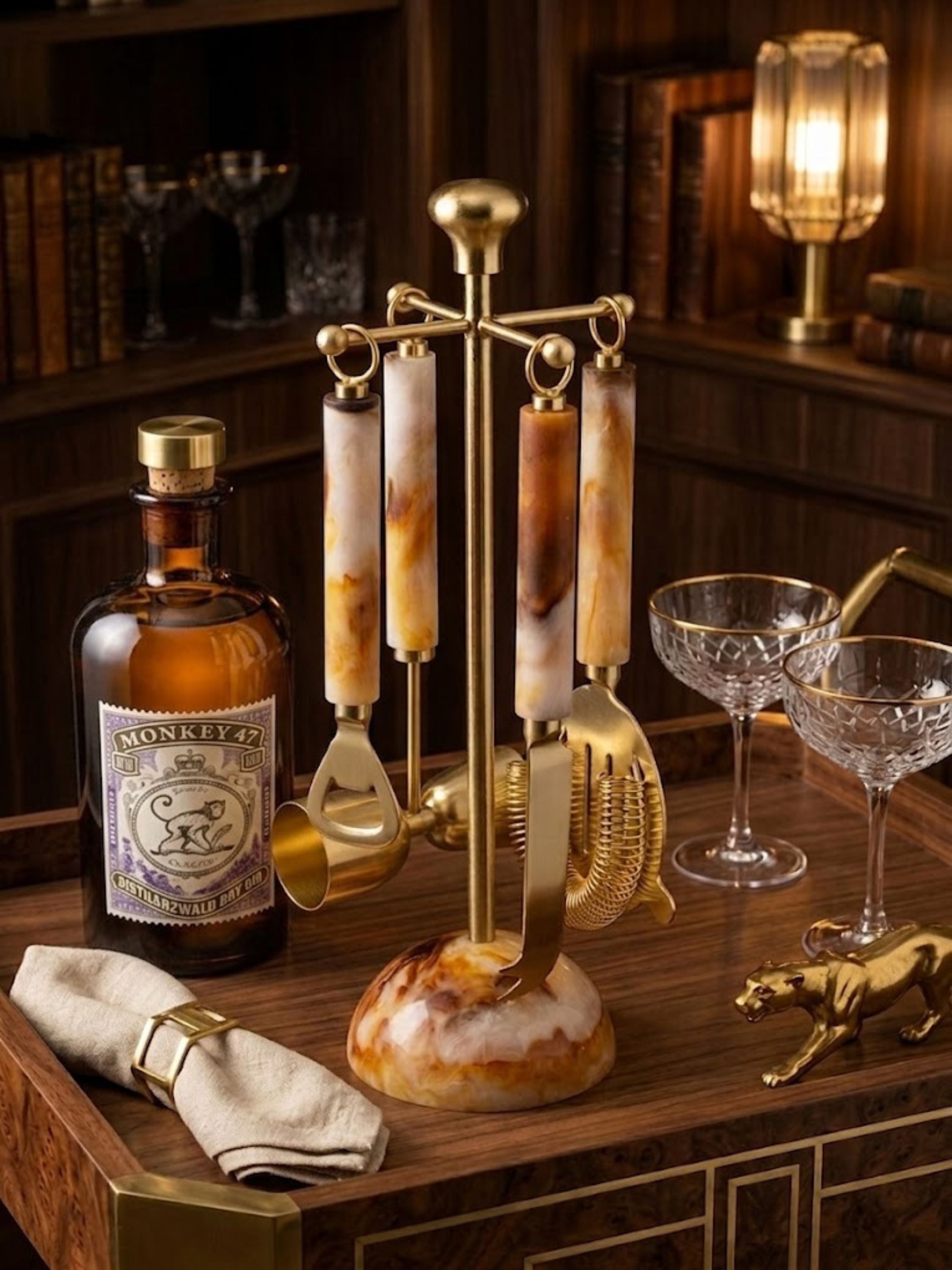 Kampai marbled resin bar tools set displayed on a refined cocktail tray, featuring warm amber resin accents and brass finishes for elevated home bar entertaining.