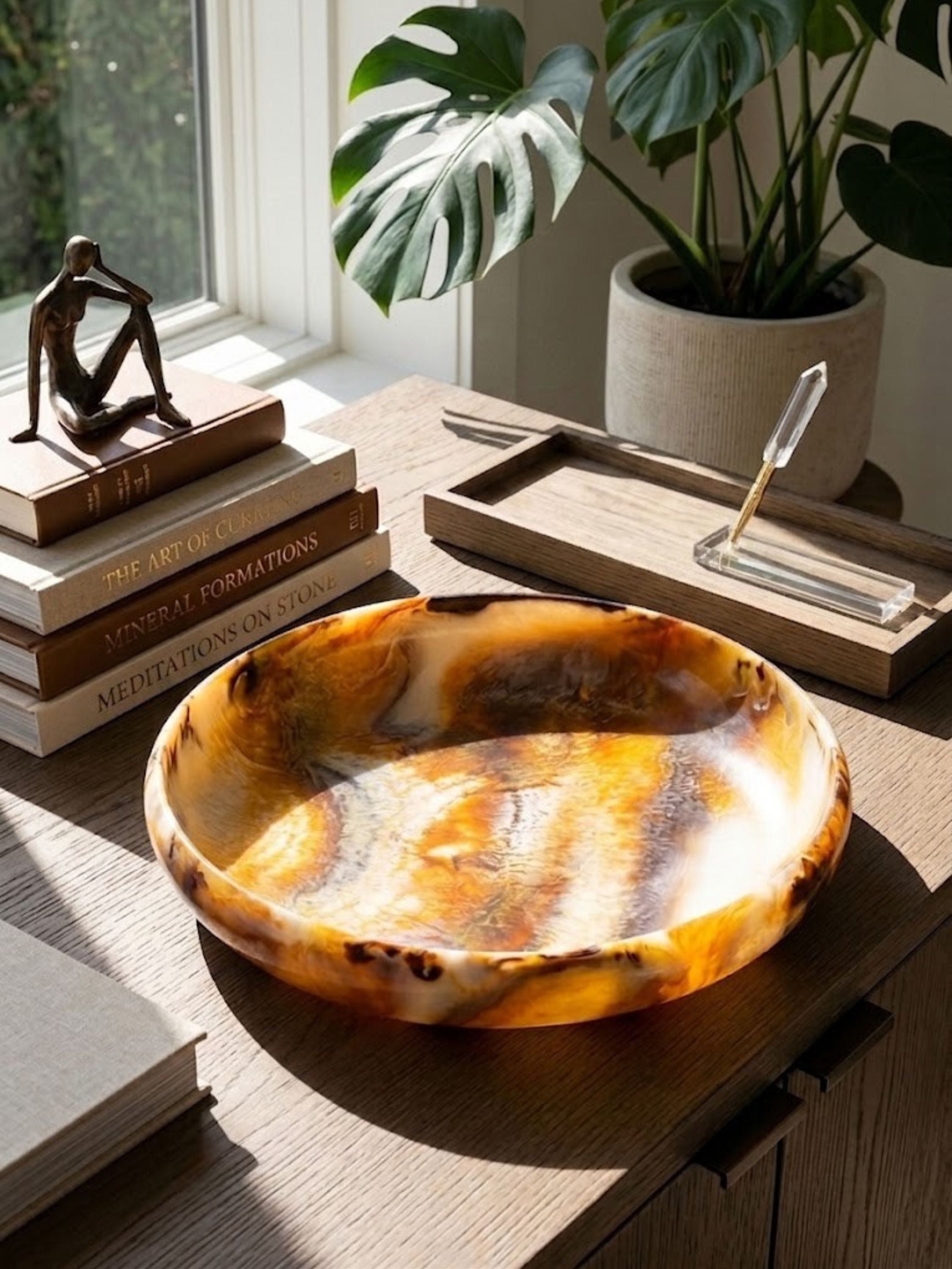 Marbled resin bowl with a deep dished interior, amber and ivory tones swirling through the base.