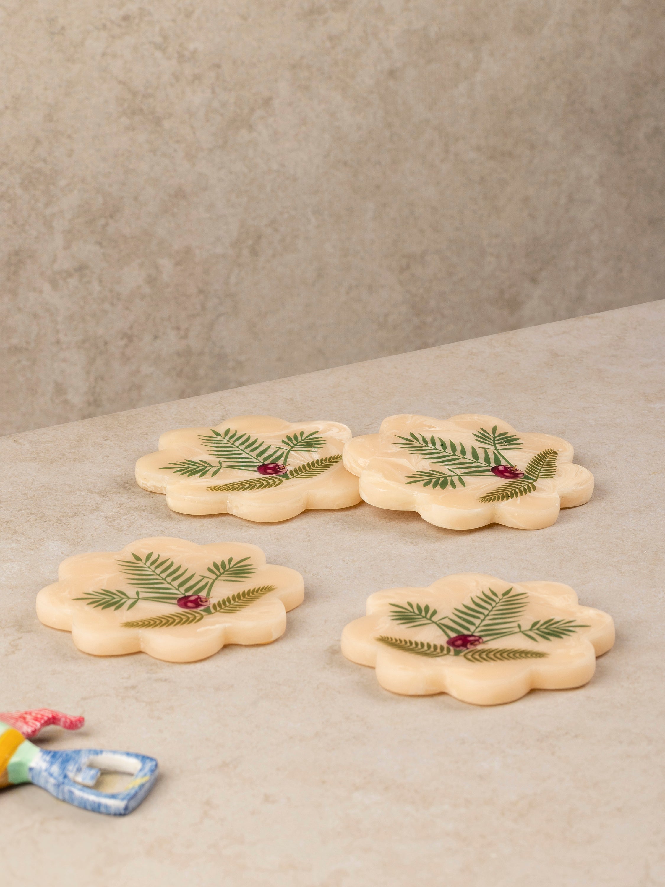 Scalloped resin coasters with botanical leaf pattern arranged together showing rounded edges and layered surface design