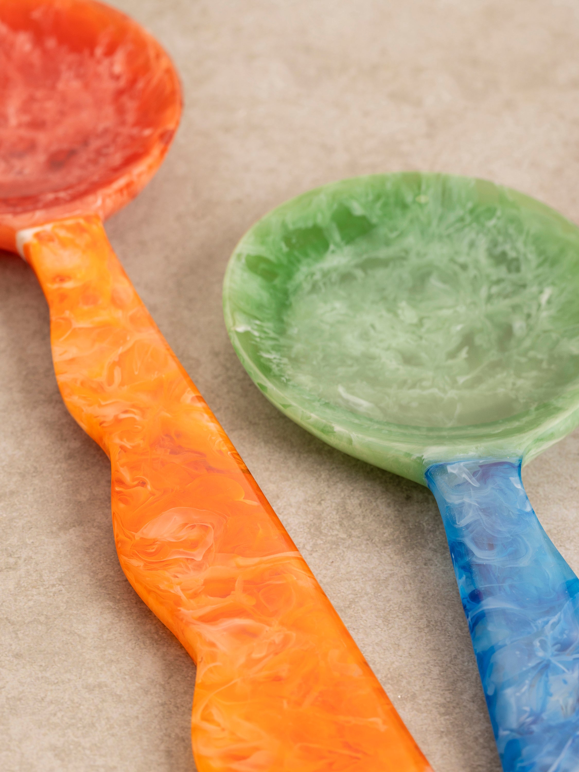 Close-up of a Hawaii server's marbled resin handle, showing fluid color movement and a smooth polished finish.