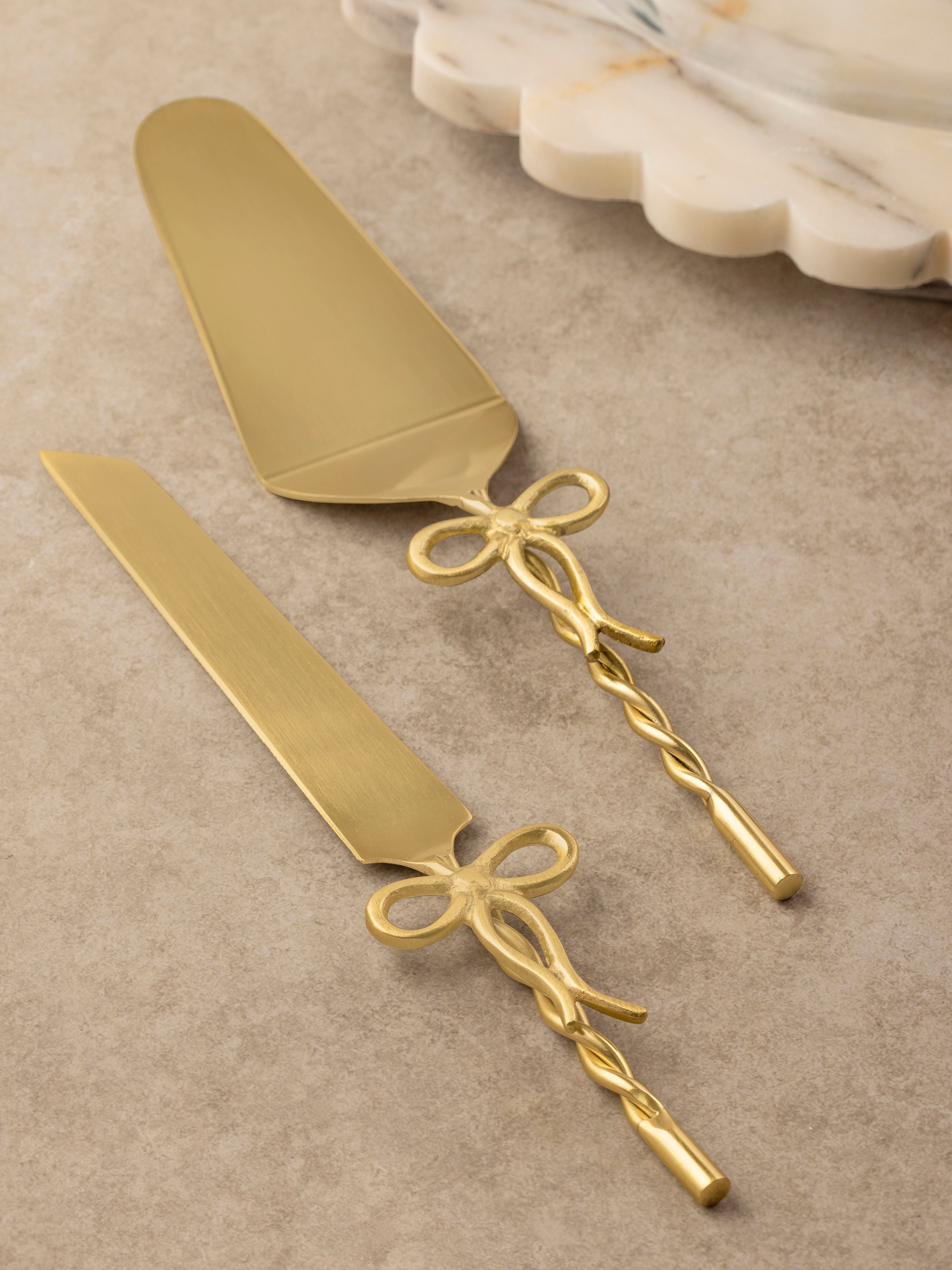 Imperial cake server set with sculpted bow-form handles arranged in a flat-lay composition.