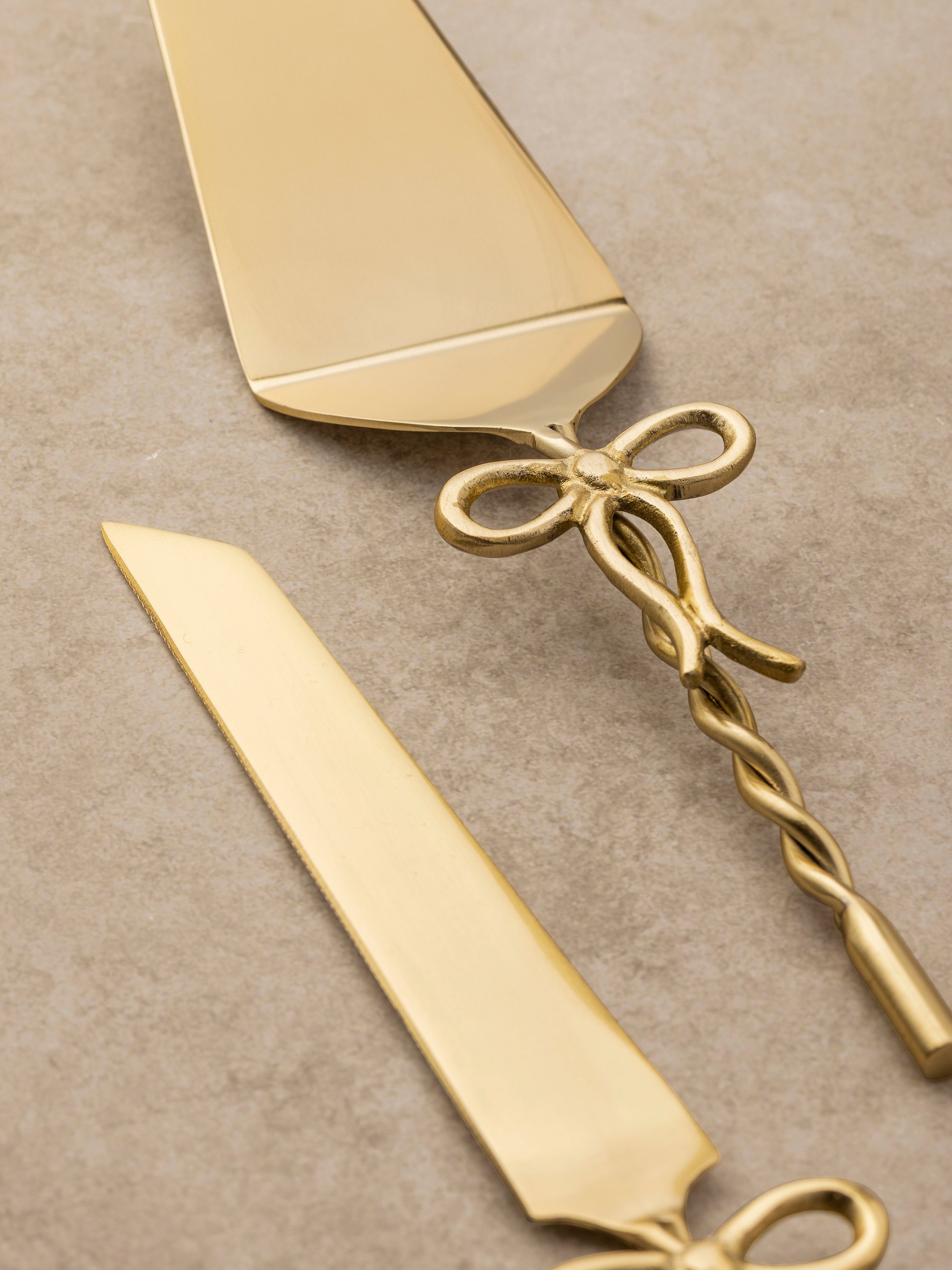Close-up of an Imperial cake server's twisted brass handle, showing its spiral structure and polished finish.