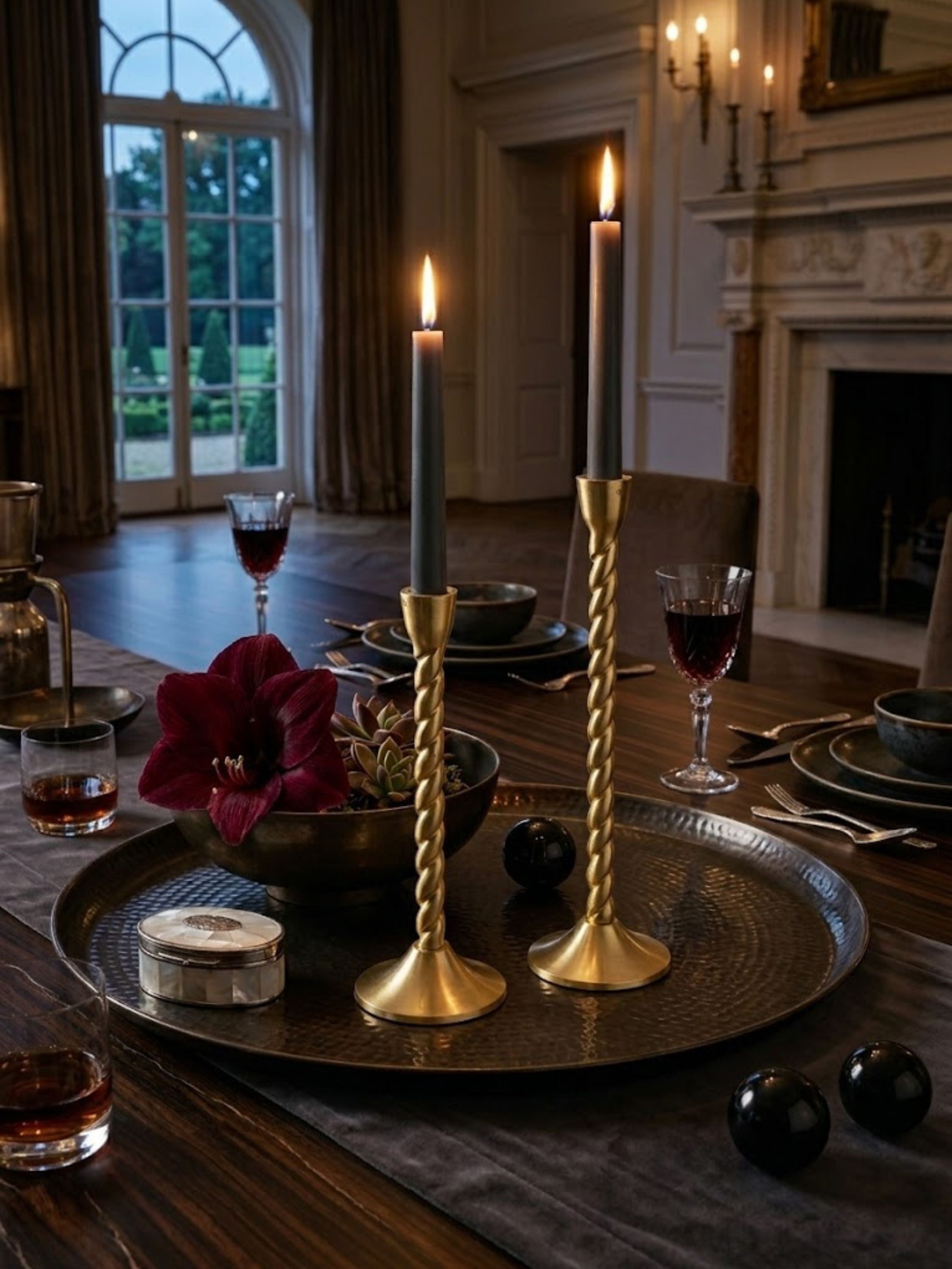 Twilight gold candle holders displayed on a marble entry console with dark taper candles, highlighting sculptural twisted stems.