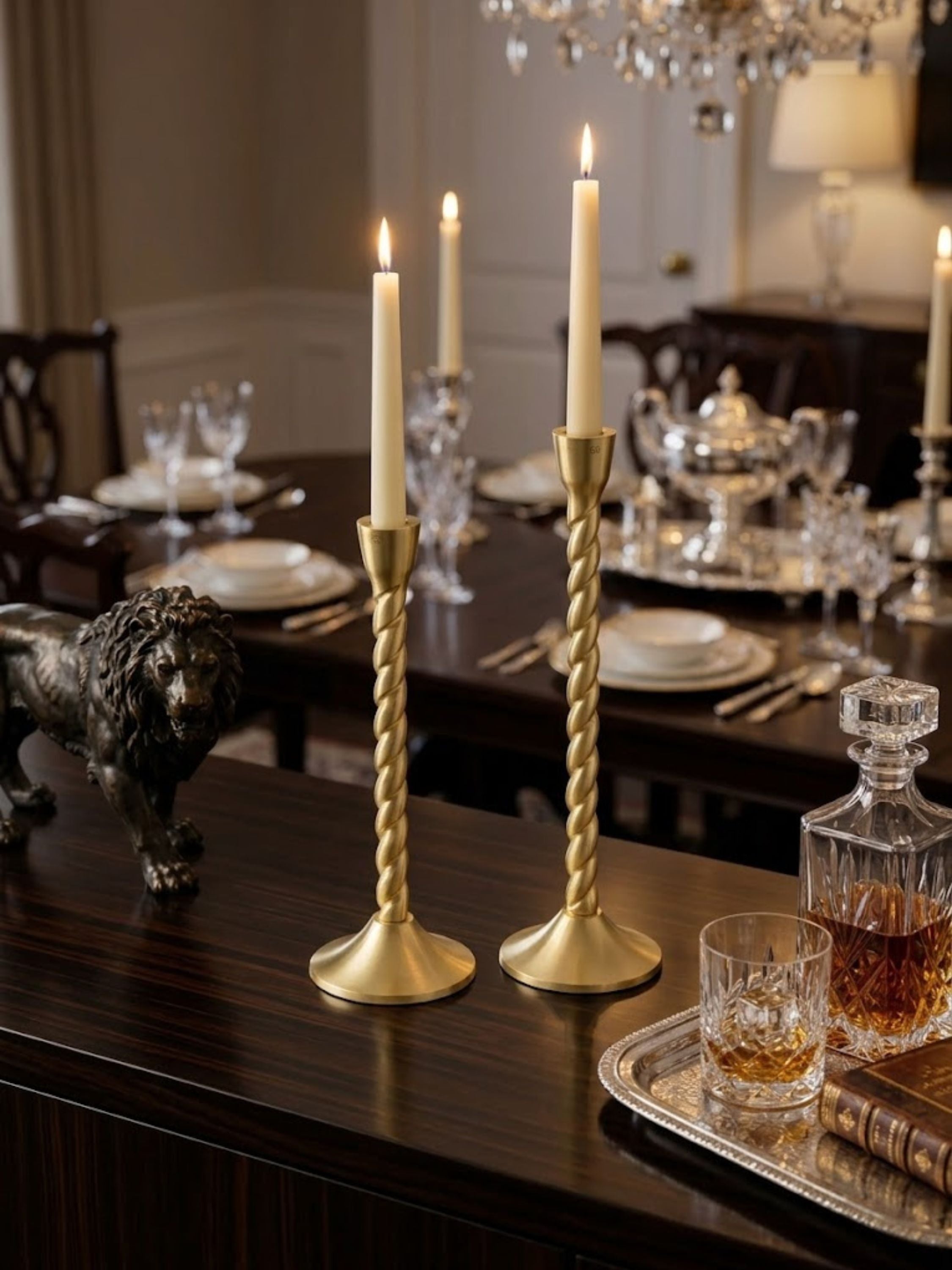 Twilight gold candle holders presented on a decorative serving tray as a dining centerpiece, featuring sculptural twisted stems and warm candlelight.