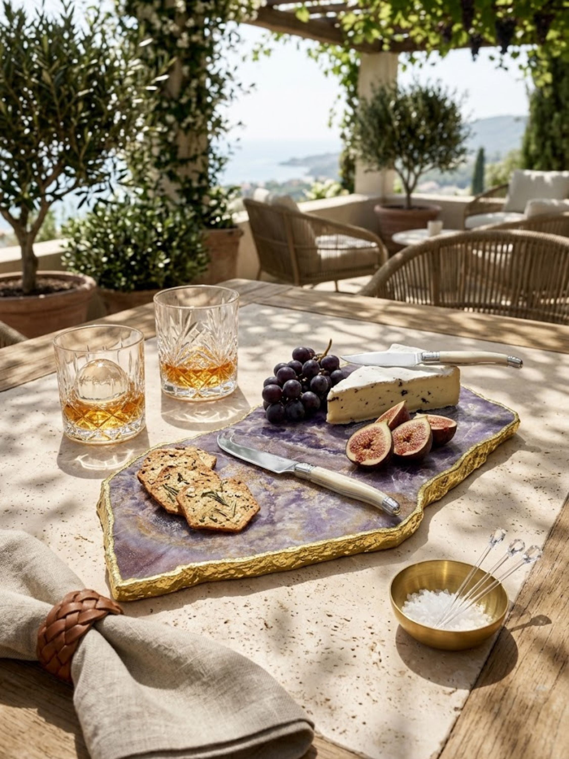 Amethyst stone cheese board with a gold rim, styled on an outdoor terrace.