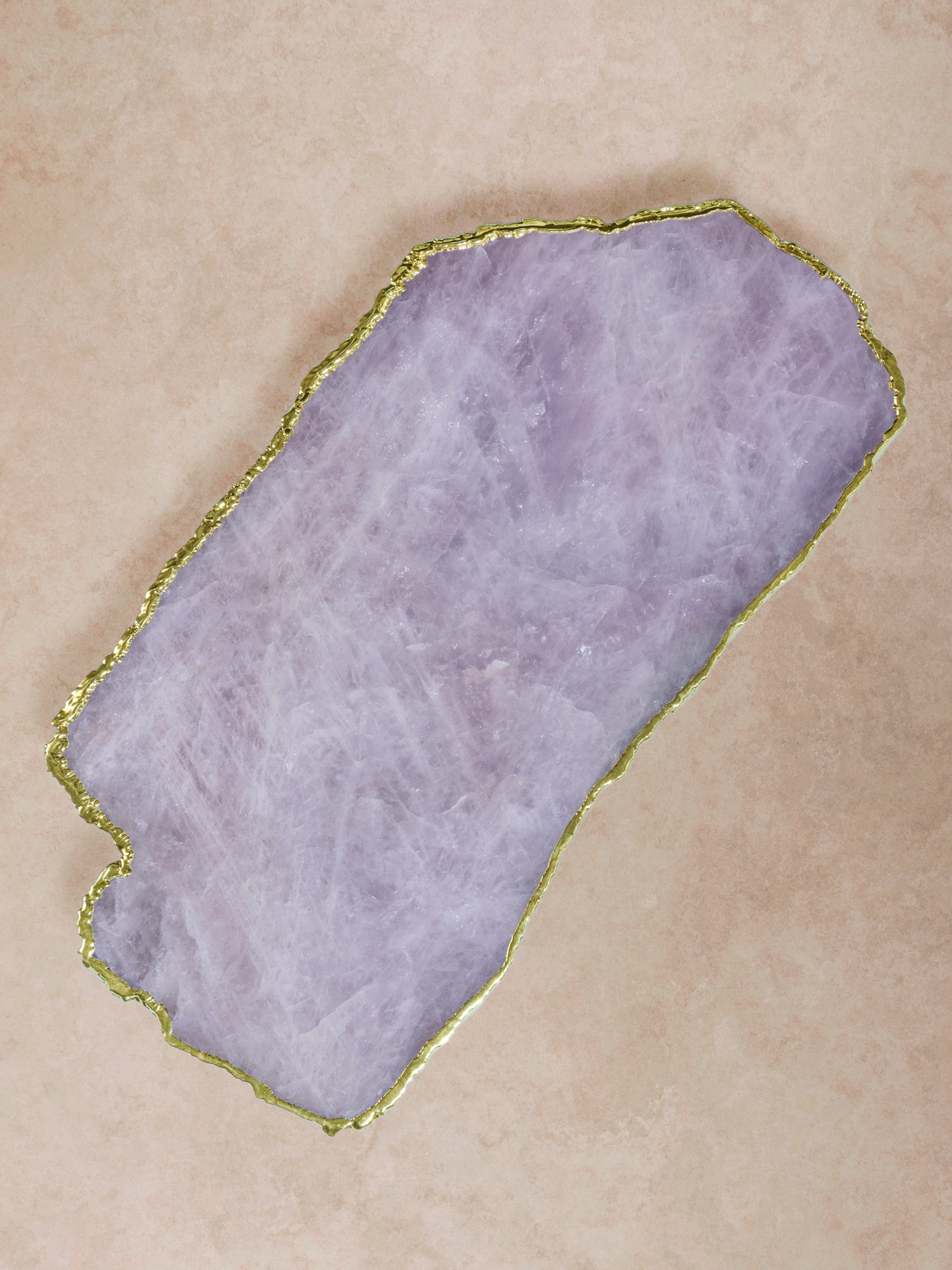 Rose quartz semi-precious stone board with soft pink tones and organic contours, framed by a fine gold gilded edge in a clean composition