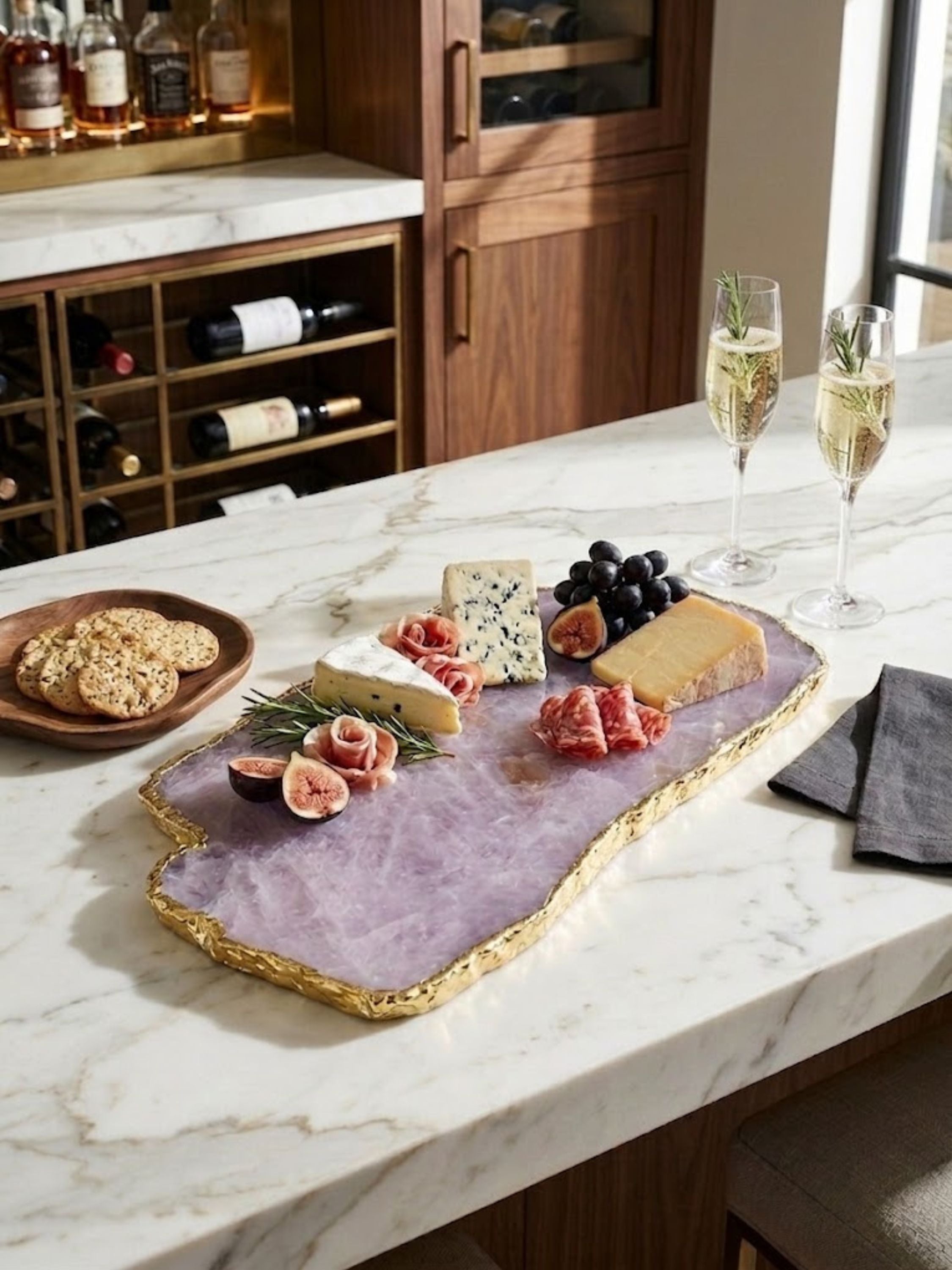 Rose quartz stone cheese board with a gilded edge, styled on a home bar.