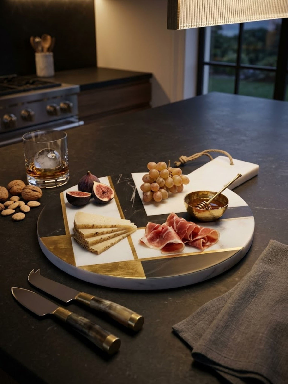White and charcoal marble cheese board with brass inlay, styled on a kitchen counter.