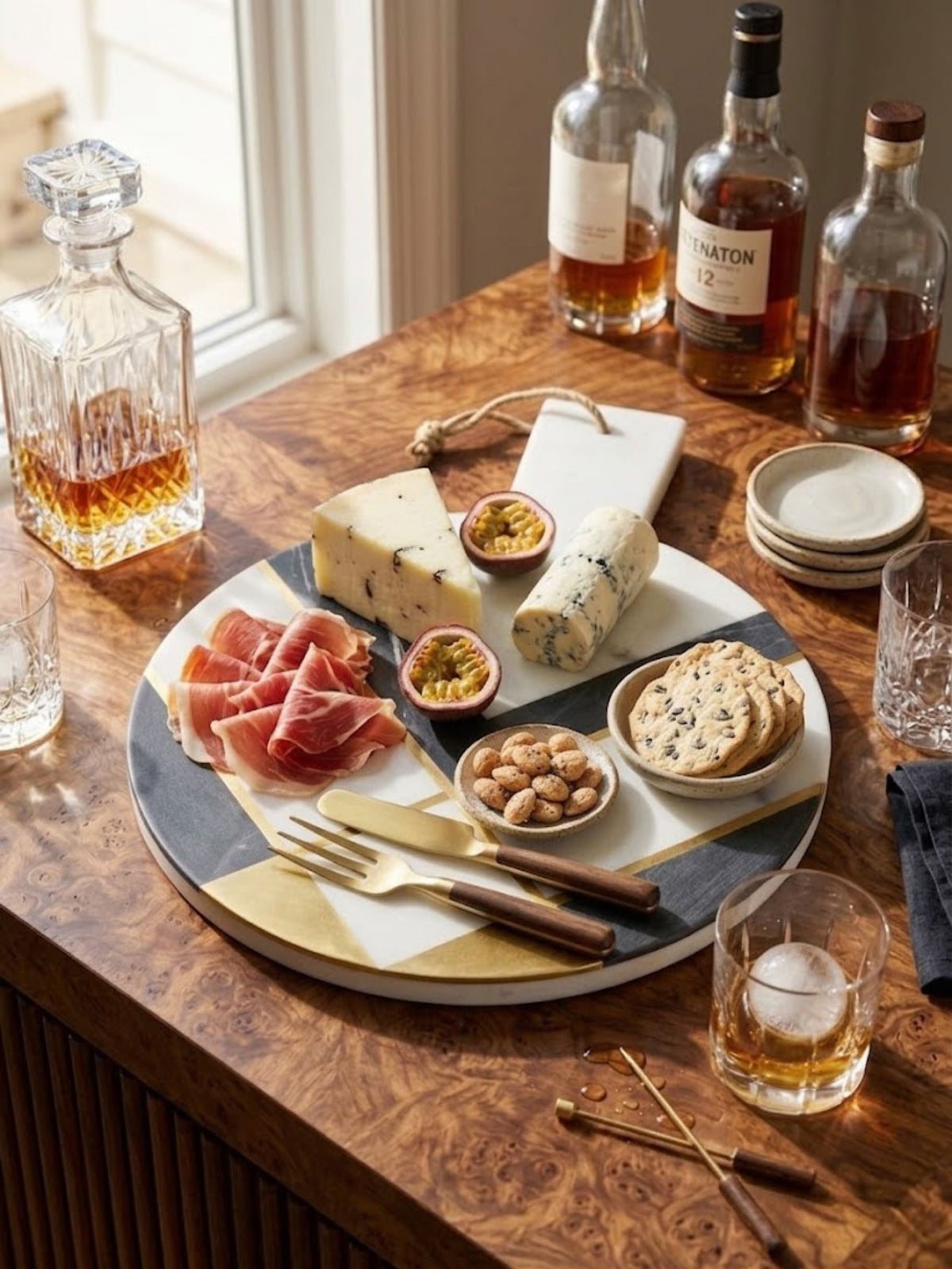 Circular white and charcoal marble cheese board, styled on a home bar counter.