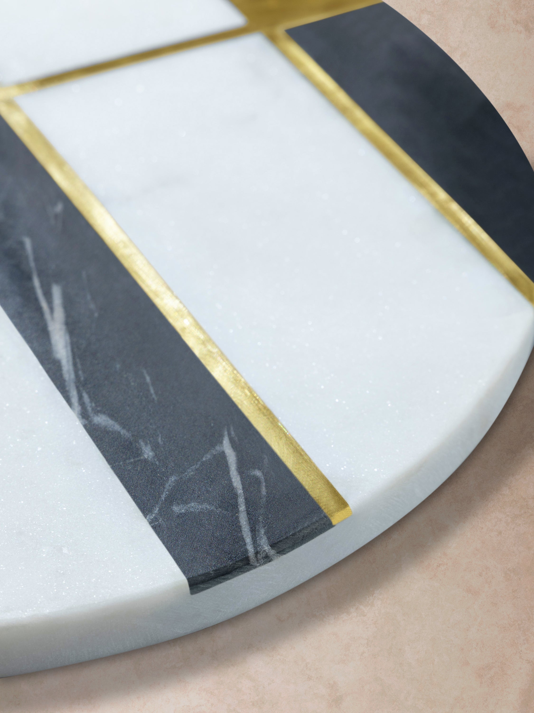 Close-up of marble board showing triangular stone inlay, smooth polished finish, and crisp edge profile with natural veining variation