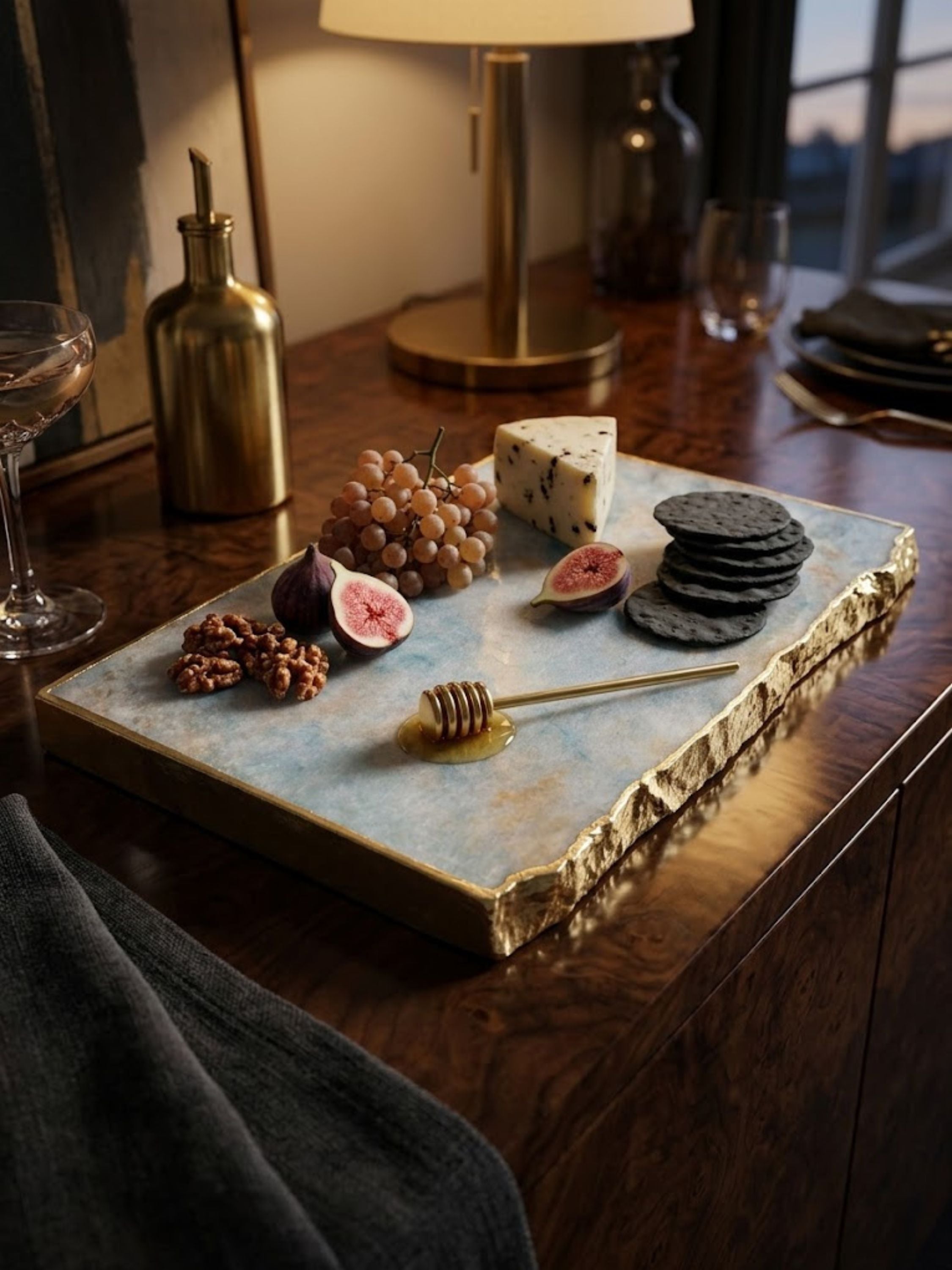 Aventurine stone cheese board with a hand-gilded edge, styled on a console table.