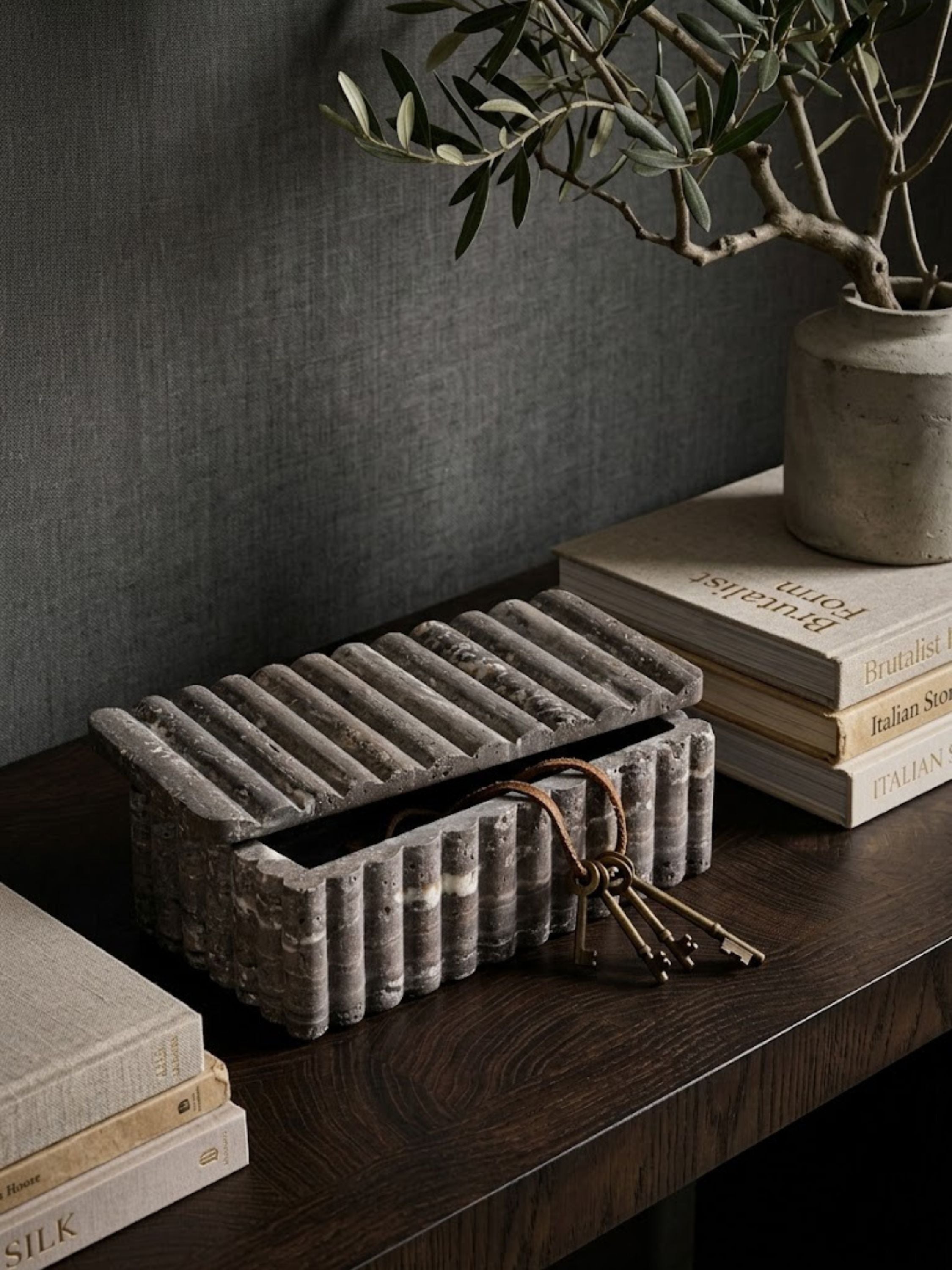 Alternate view of the Cuba travertine box on a console table, showing its ribbed texture and fitted lid from a different angle.