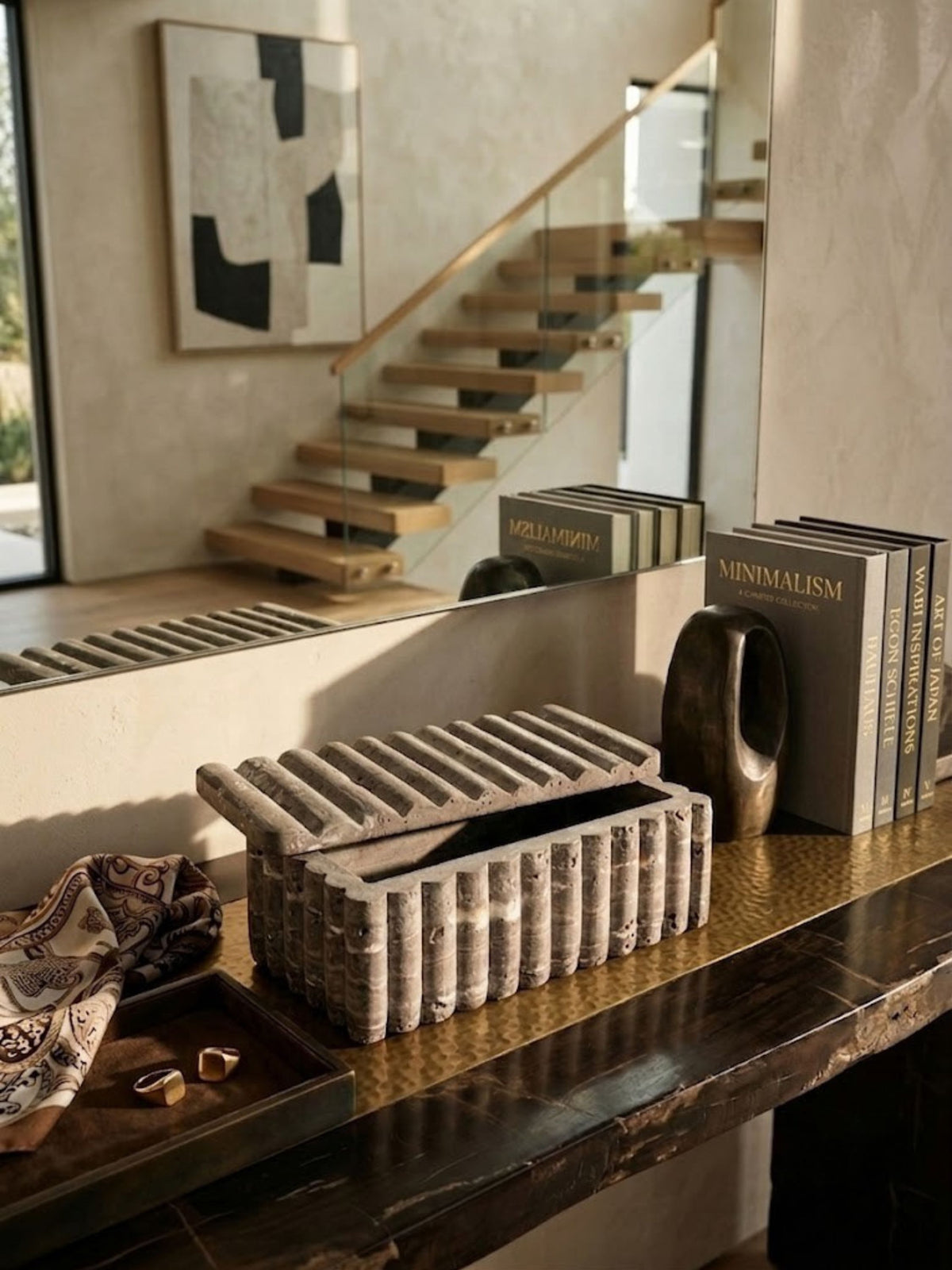 Gray travertine ribbed box styled on an entryway console table.