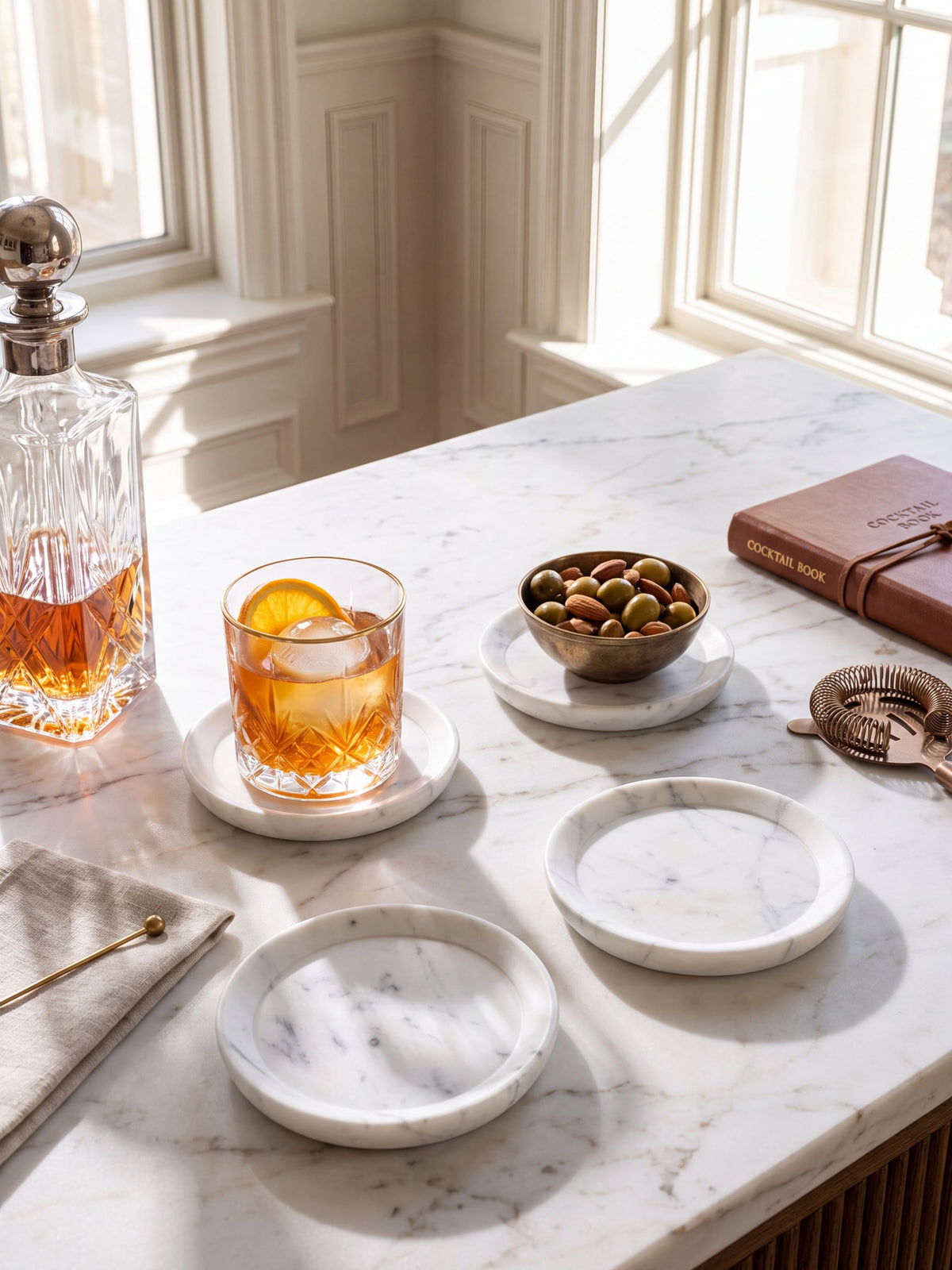 White marble coasters with grey veining, styled on a table with coffee cups and a pastry.