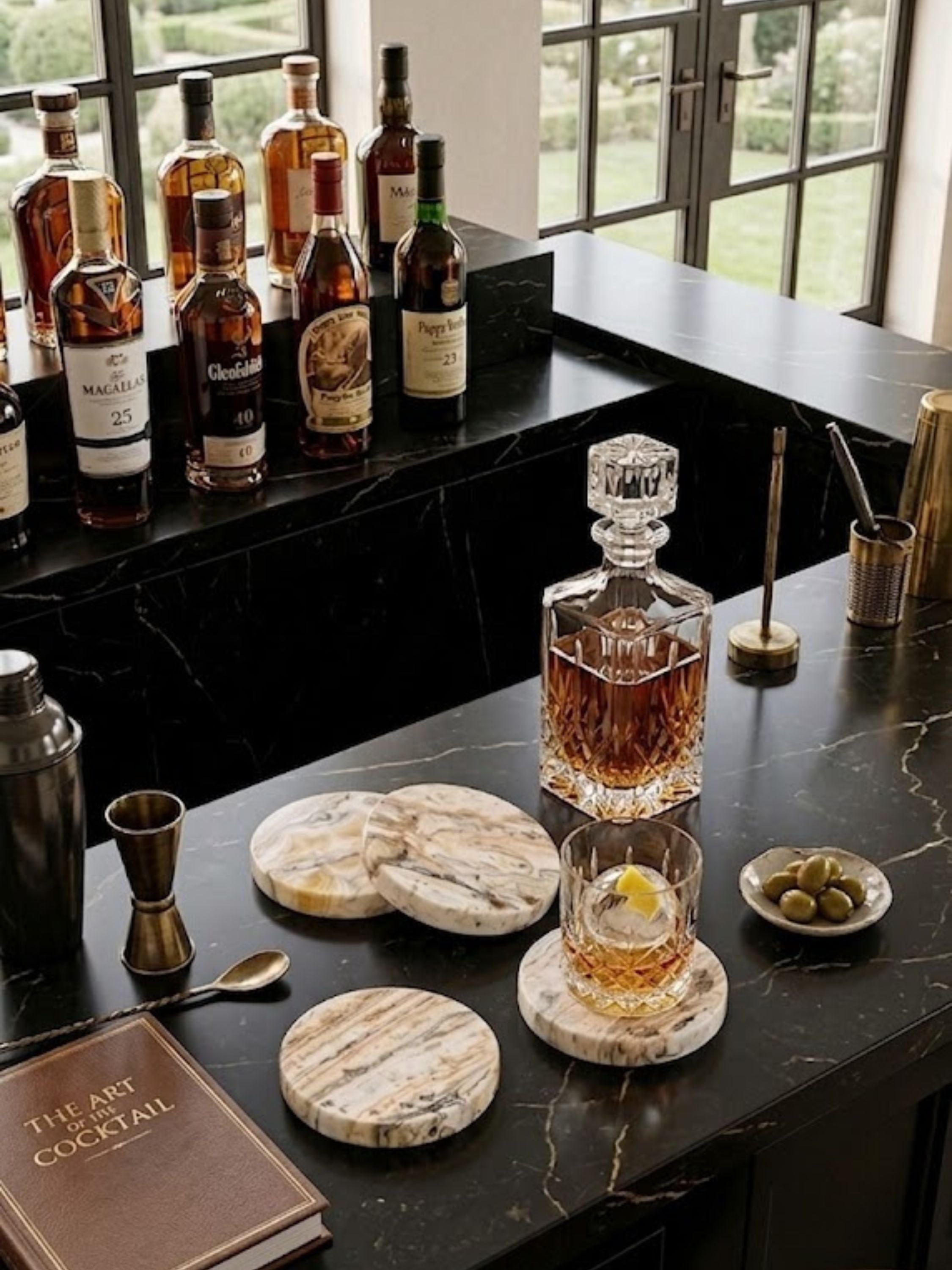 Onyx coasters, set of four, with natural veining, placed on a dark stone countertop with decanter, glassware, and bar tools