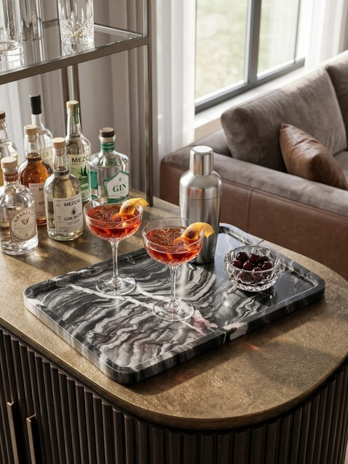 Frontier black onyx tray with sweeping gray veining, holding cocktails and garnishes at a home bar.