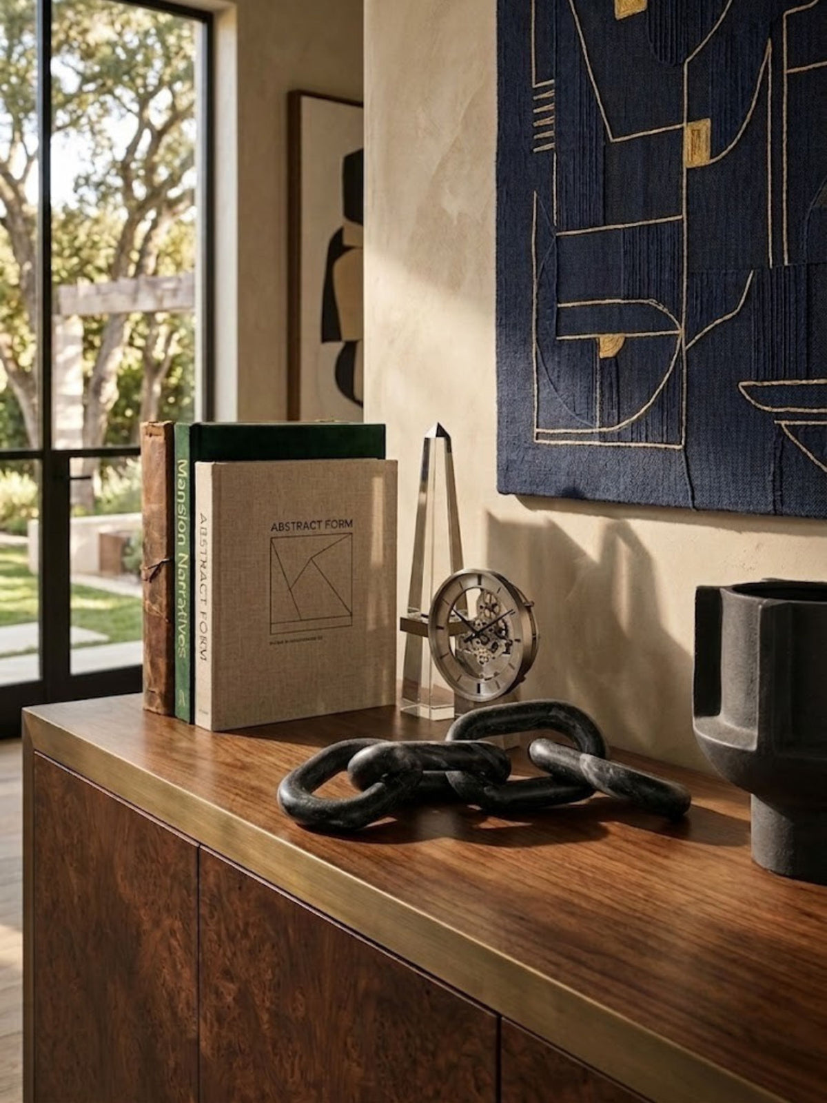 Black marble chain-link sculpture styled on a living room console.