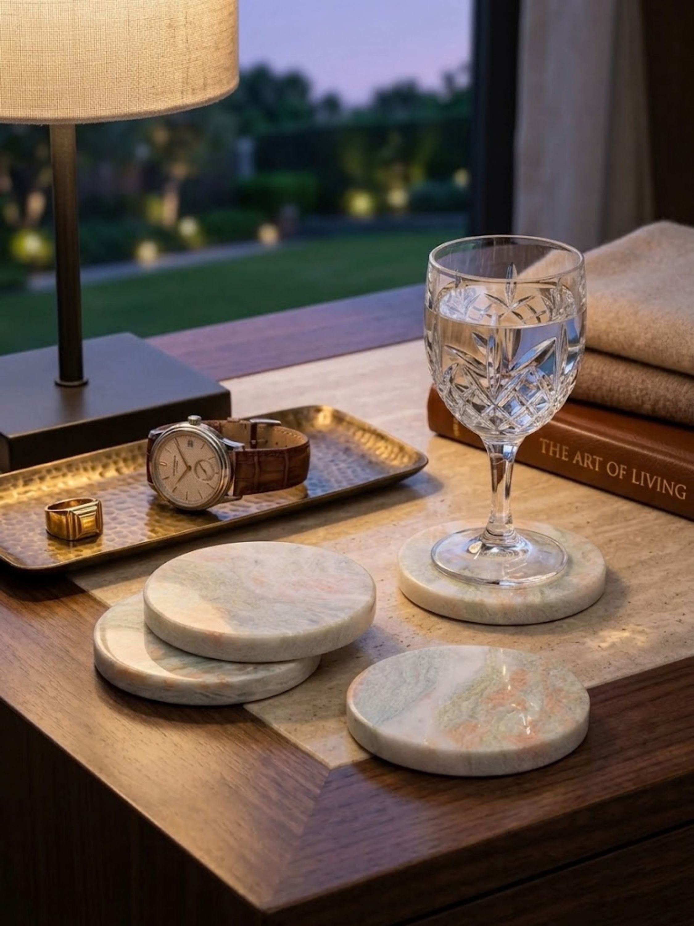 Moonlight onyx coasters styled on a bedside table with a crystal glass and personal accessories, adding a calm touch to everyday living spaces.