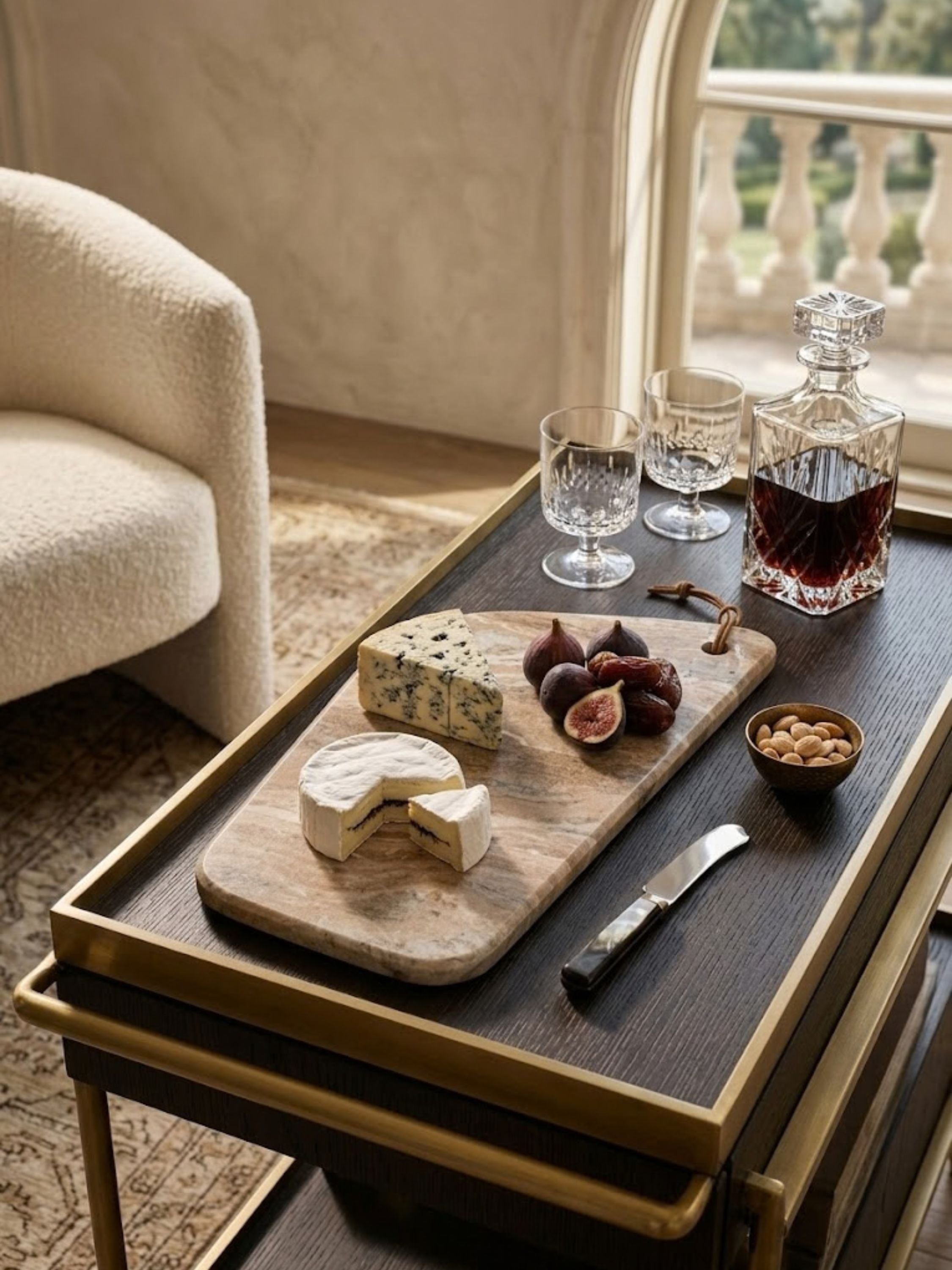 Dakota marble cheese board styled on a serving tray with cheeses, fresh figs, and crystal glassware.
