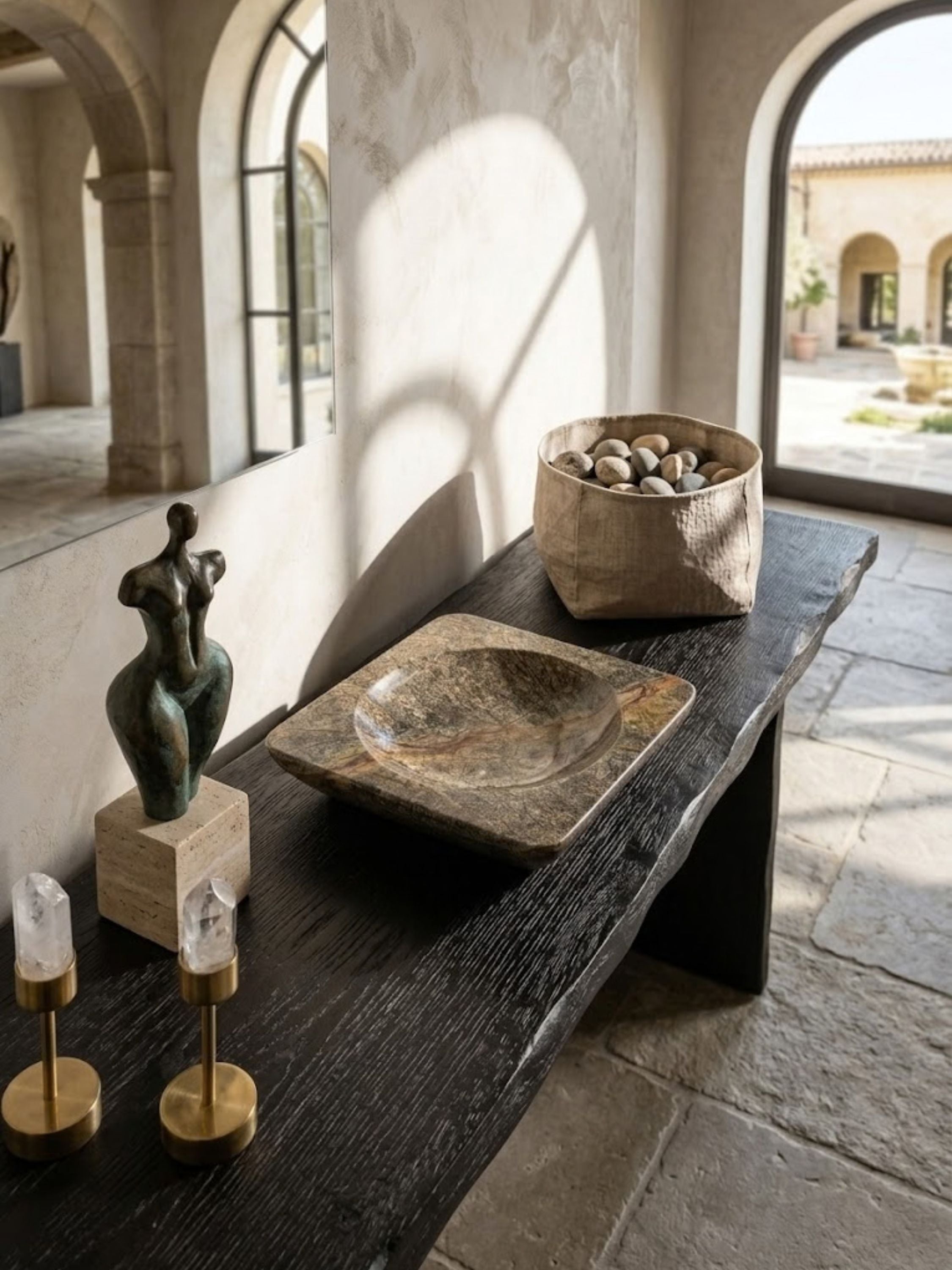Selva Verde green stone bowl styled on a rustic wood console table, highlighting rich green veining and sculptural presence.