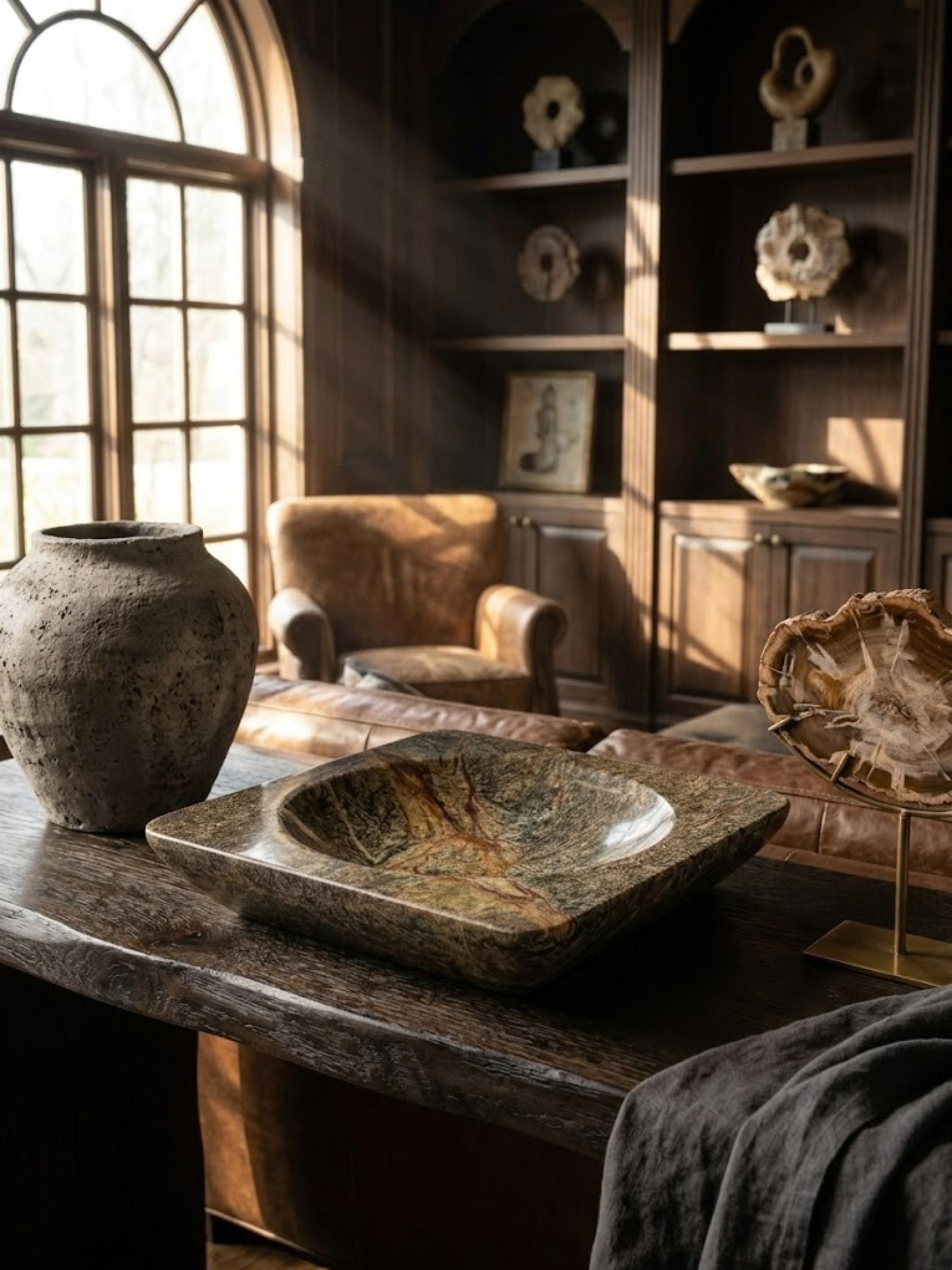 Selva Verde green stone bowl styled on a library console with curated objects, bringing layered stone texture to the space.
