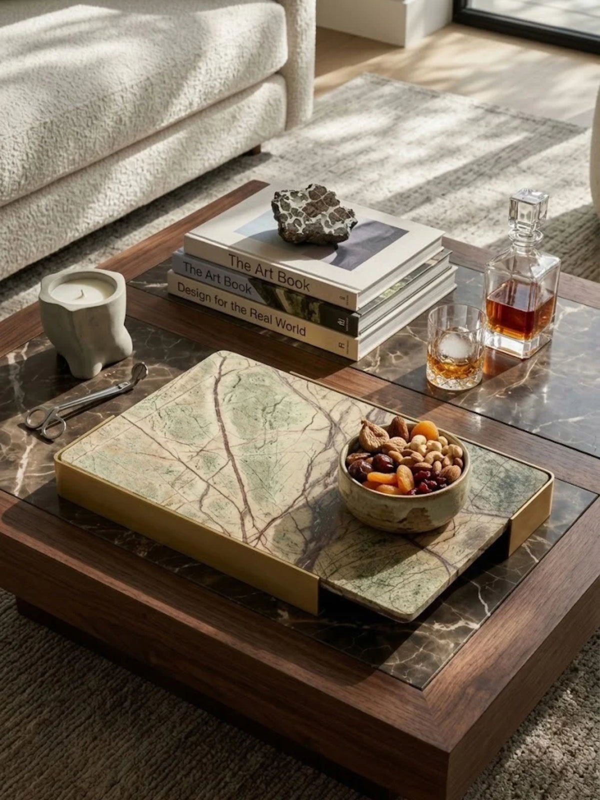 Normandy onyx marble tray with brushed gold handles, holding a bowl and decanter on a coffee table.