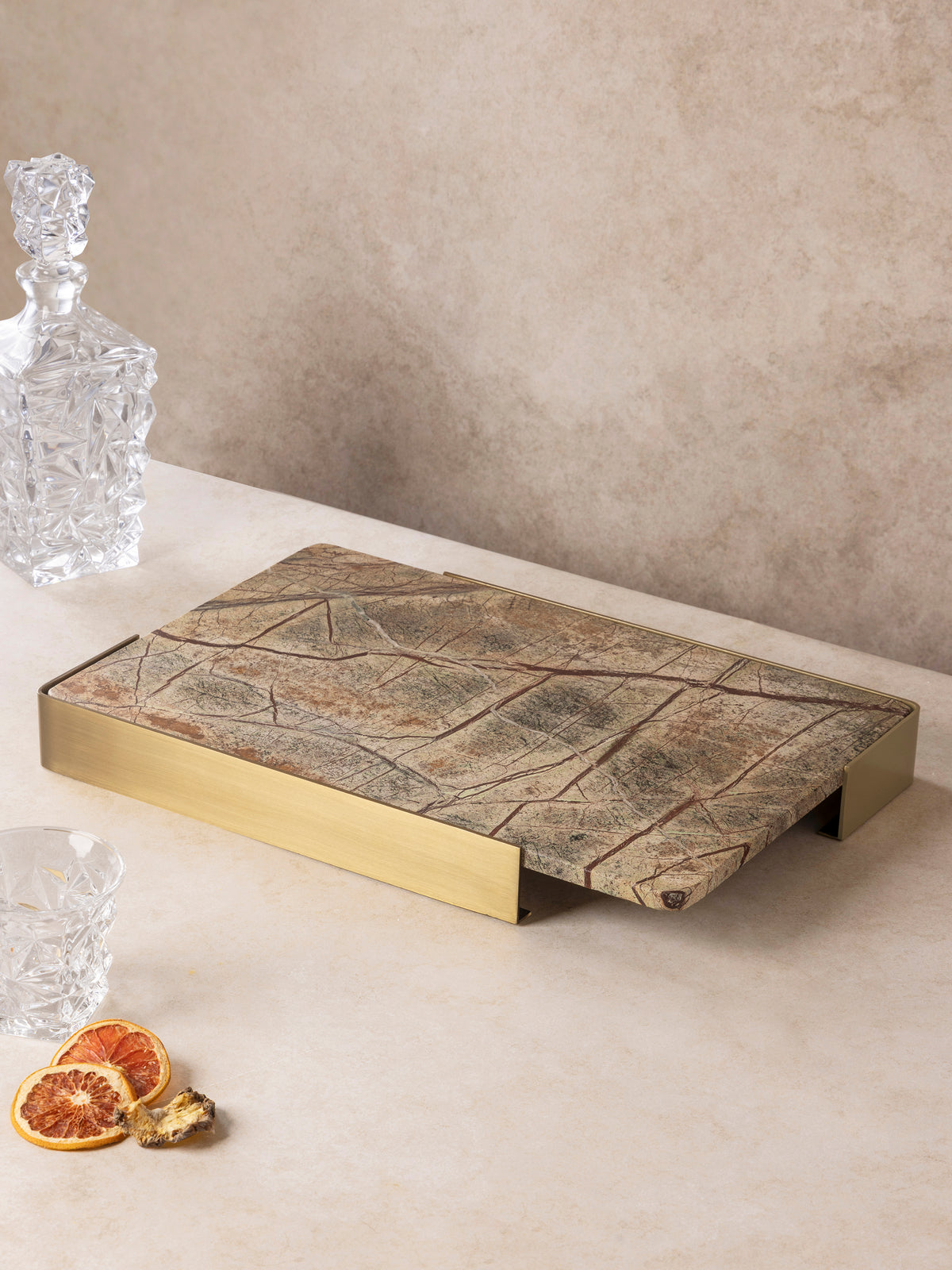 Normandy onyx marble tray seen from the side, brushed gold handles wrapping each end of the stone slab.