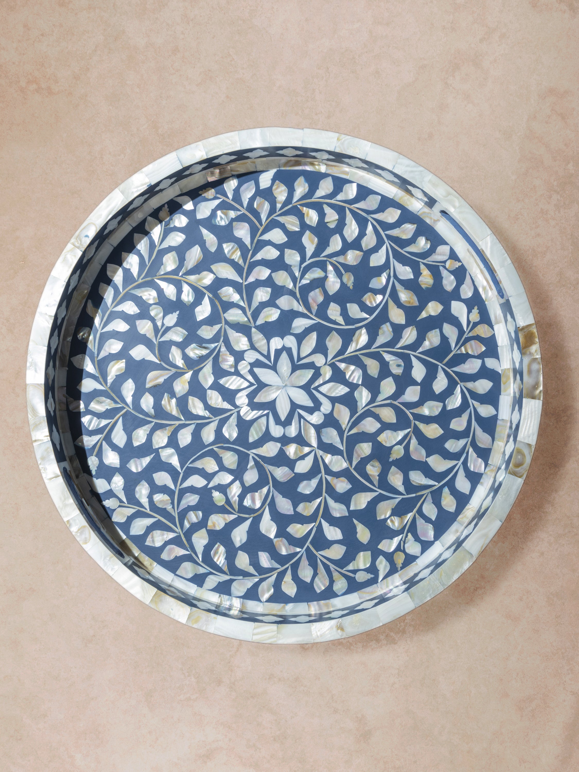 Round tray with blue ground and dense floral inlay pattern, presented in a centered top-down composition