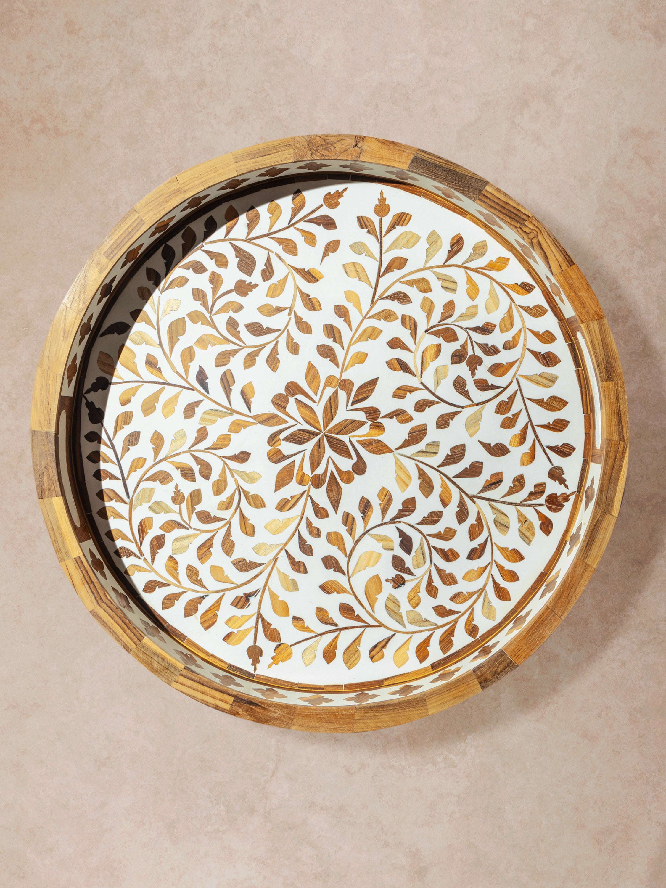 Round tray with brown ground and dense floral inlay pattern, presented in a clean top-down composition
