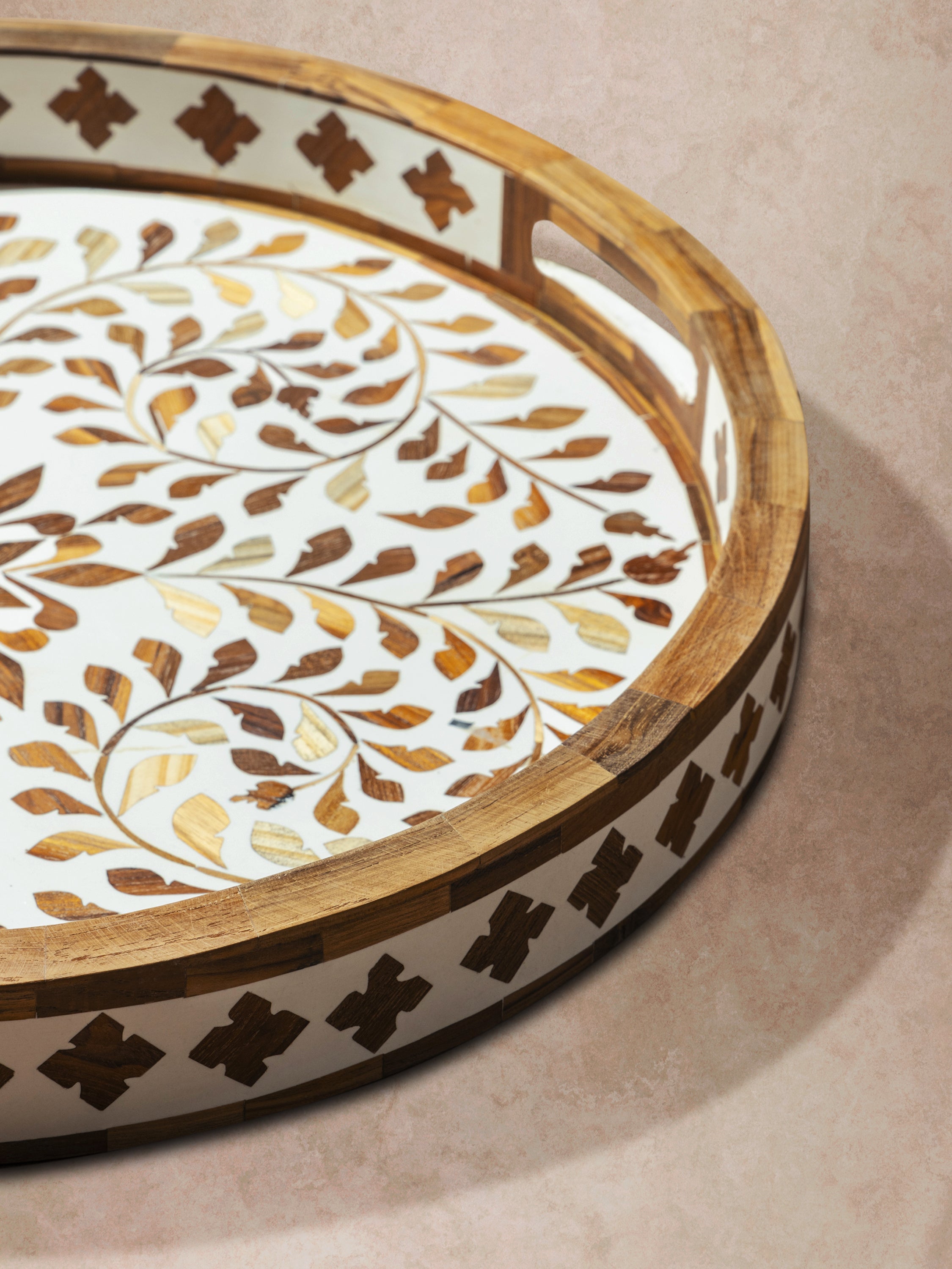 Close-up of brown inlay tray showing polished rim, layered inlay work, and contrast between wood base and shell pattern