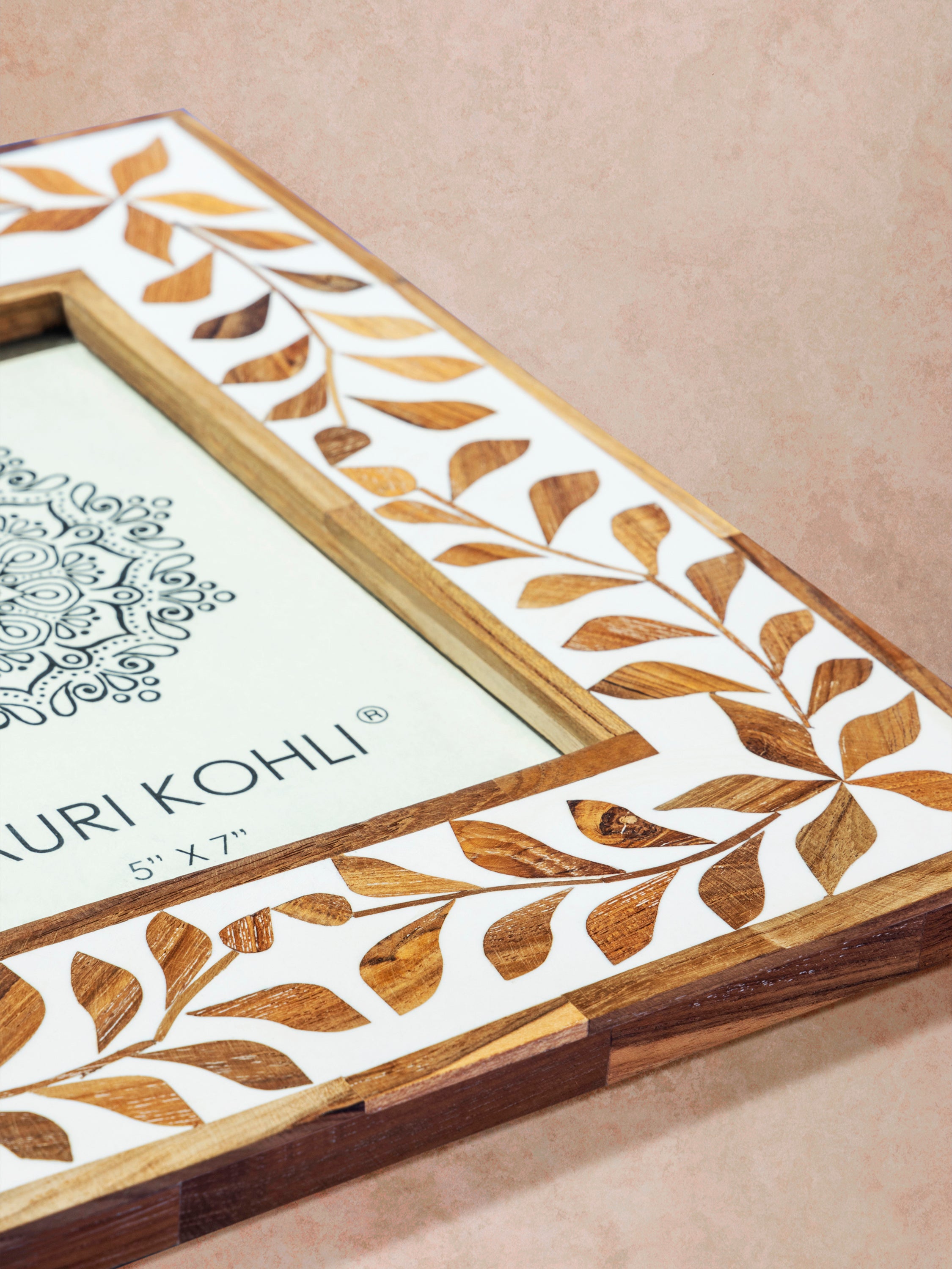 Close-up of natural tone frame highlighting bone inlay pattern, polished wood edges, and contrast between materials