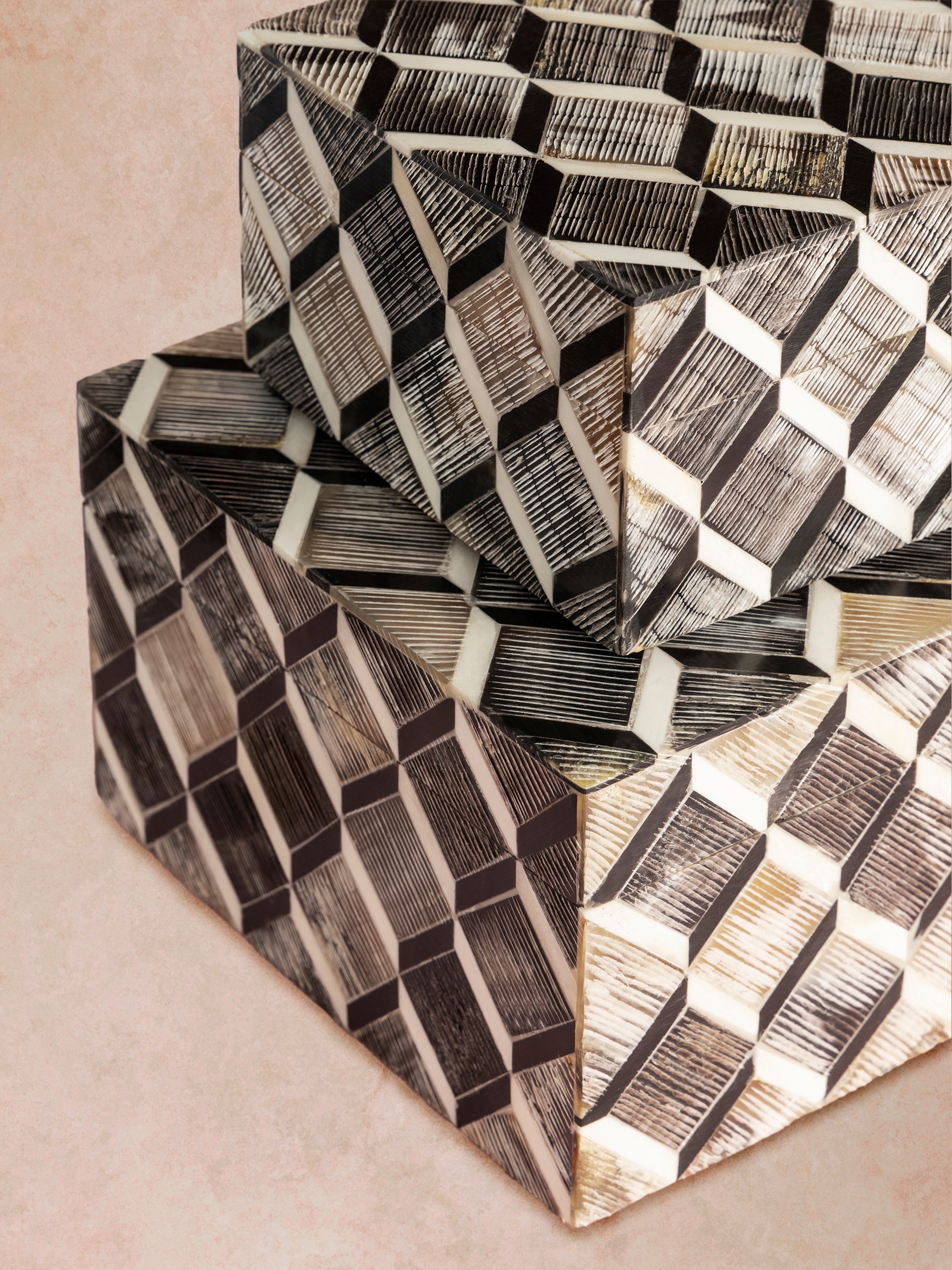 Close-up of decorative box showing raised tessellated inlay, precise angular joints, and contrast between light and dark bone segments across the textured surface