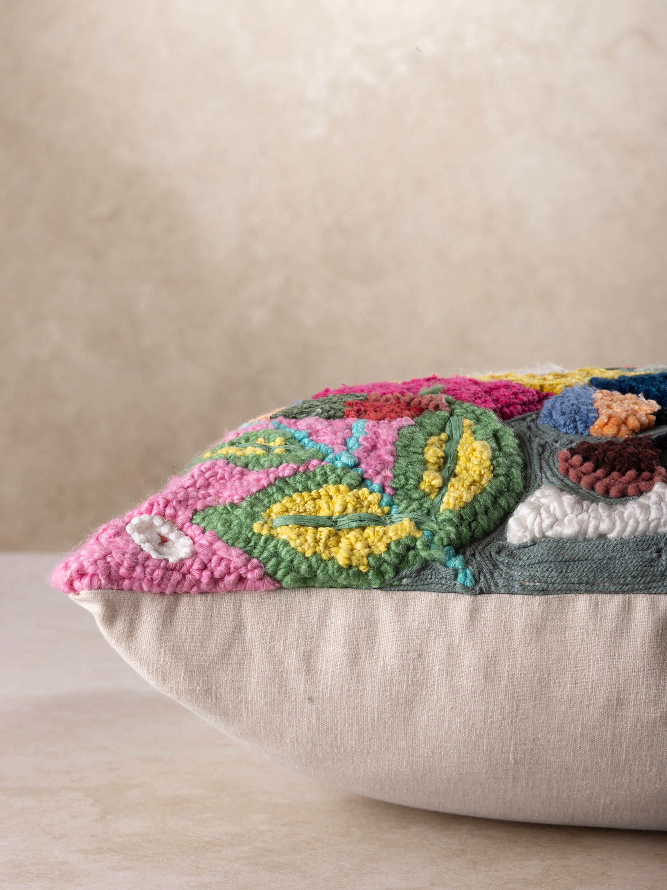 Unique decorative pillow with colorful floral embroidery and raised tufted details, creating a cozy and stylish accent piece