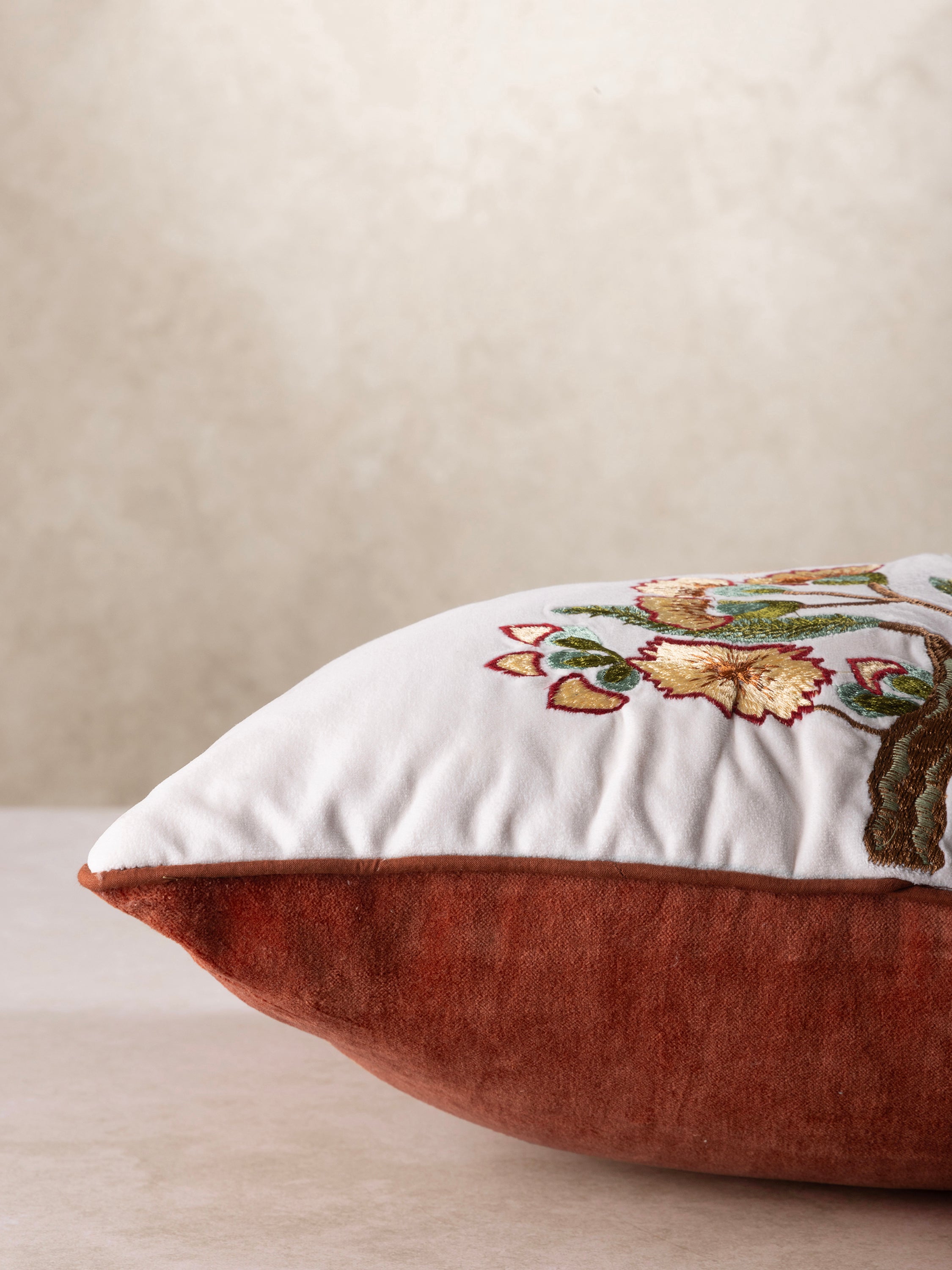 Beautifully crafted throw pillow with a detailed embroidered design of two birds in warm tones, framed by elegant floral elements
