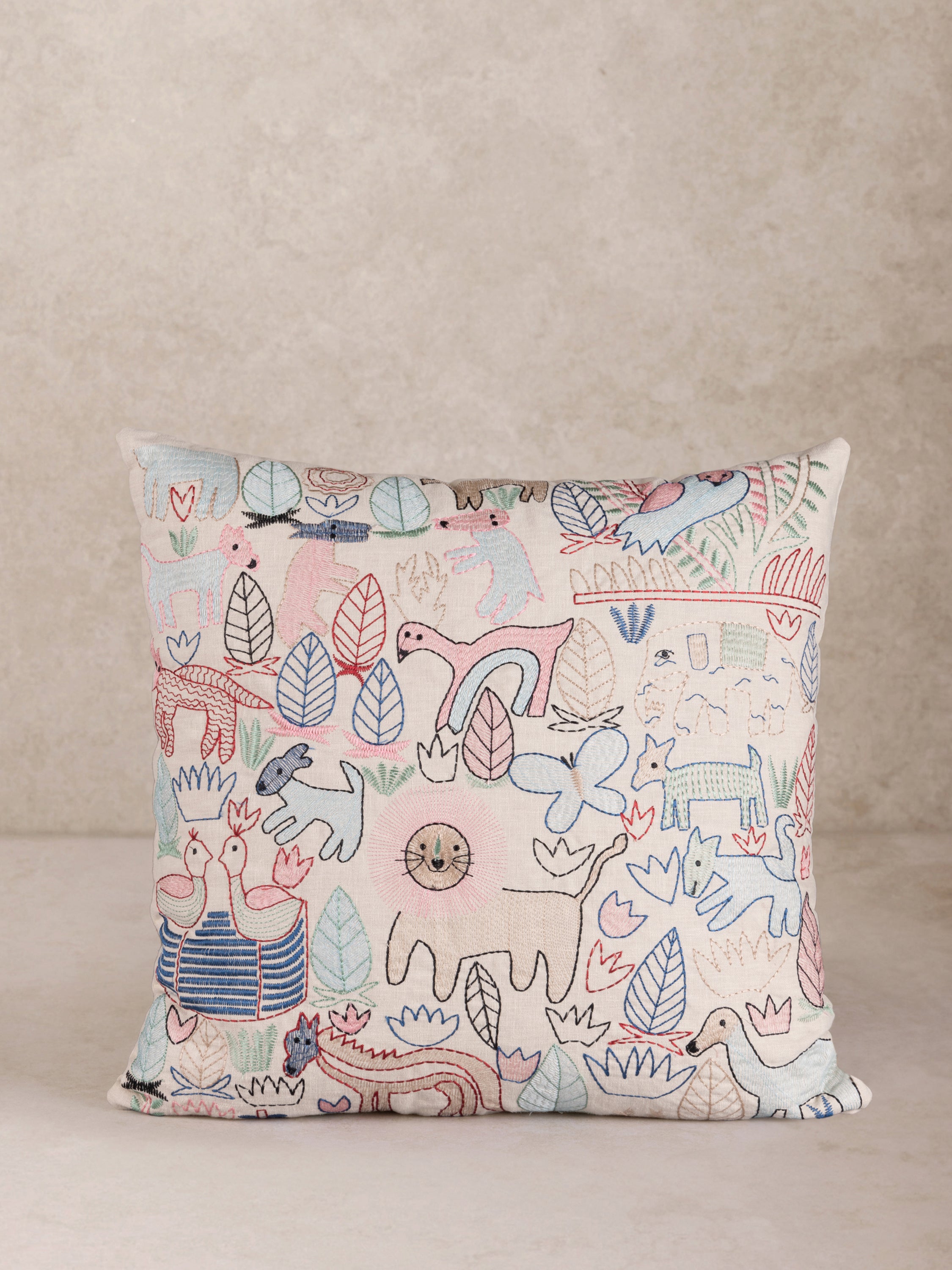 Hand-Embroidered Animal Throw Pillow with Playful Sketch Design – A charming decorative pillow featuring colorful, hand-stitched animal and nature motifs on a soft beige fabric