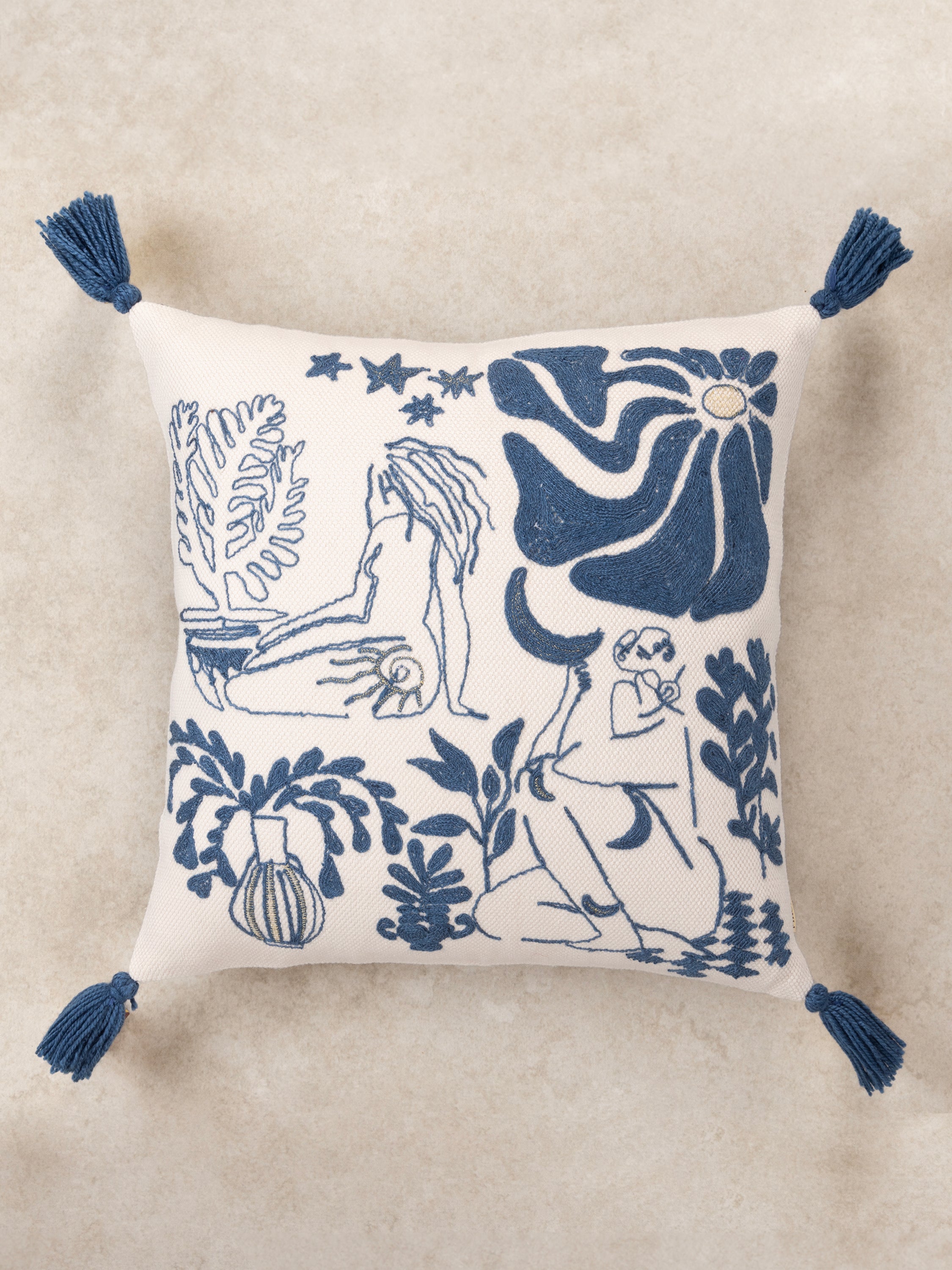 Boho Chic Tassel Pillow with Artistic Blue Embroidery – A high-quality, textured cushion with intricate embroidery showcasing abstract floral and human figure motifs, finished with decorative tassels on each corner