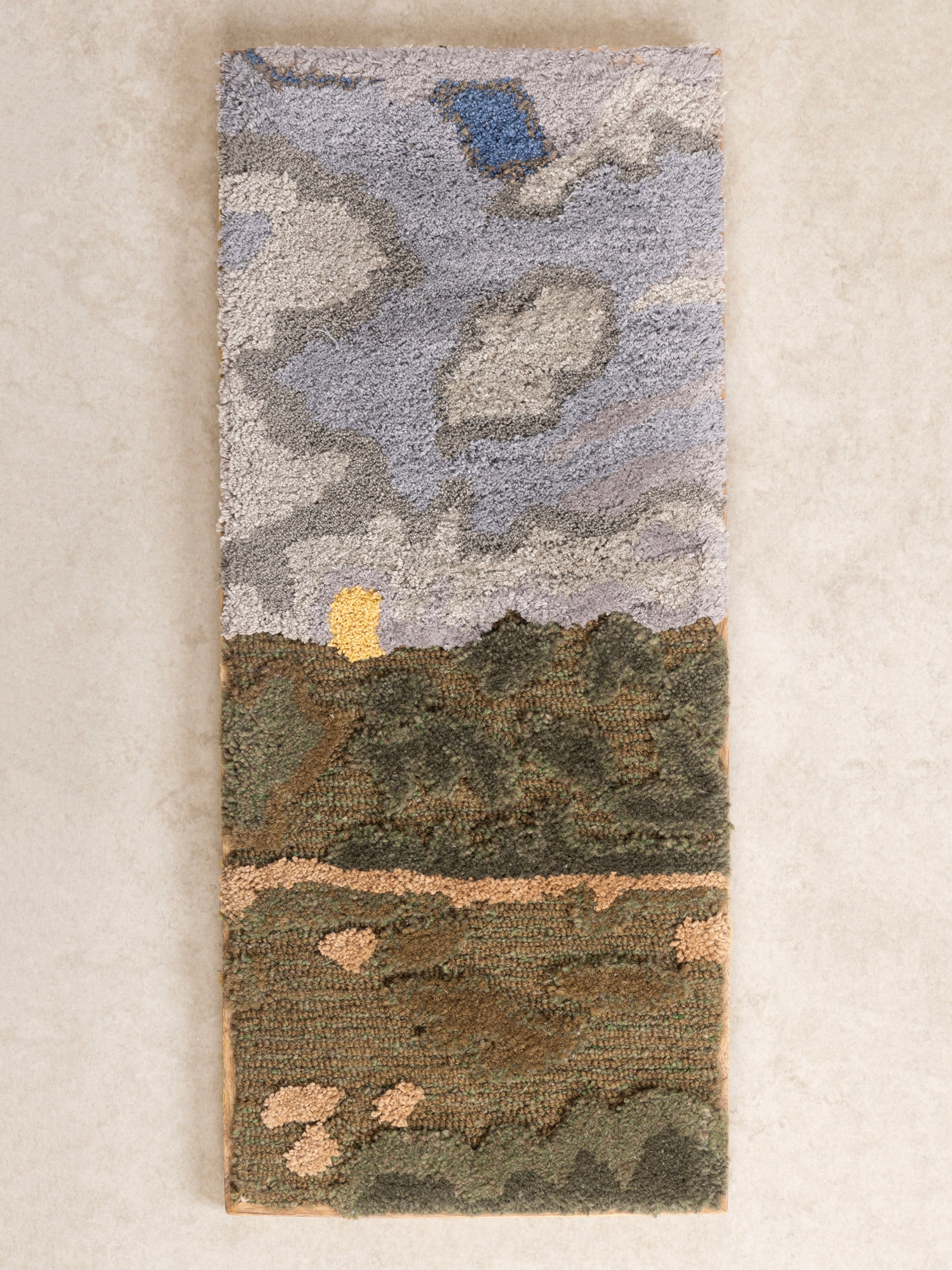 Hand-Tufted Wall Art with Moody Sky & Landscape Design – A beautifully textured fiber art piece featuring a cloudy sky over rolling hills in earthy green and gray tones