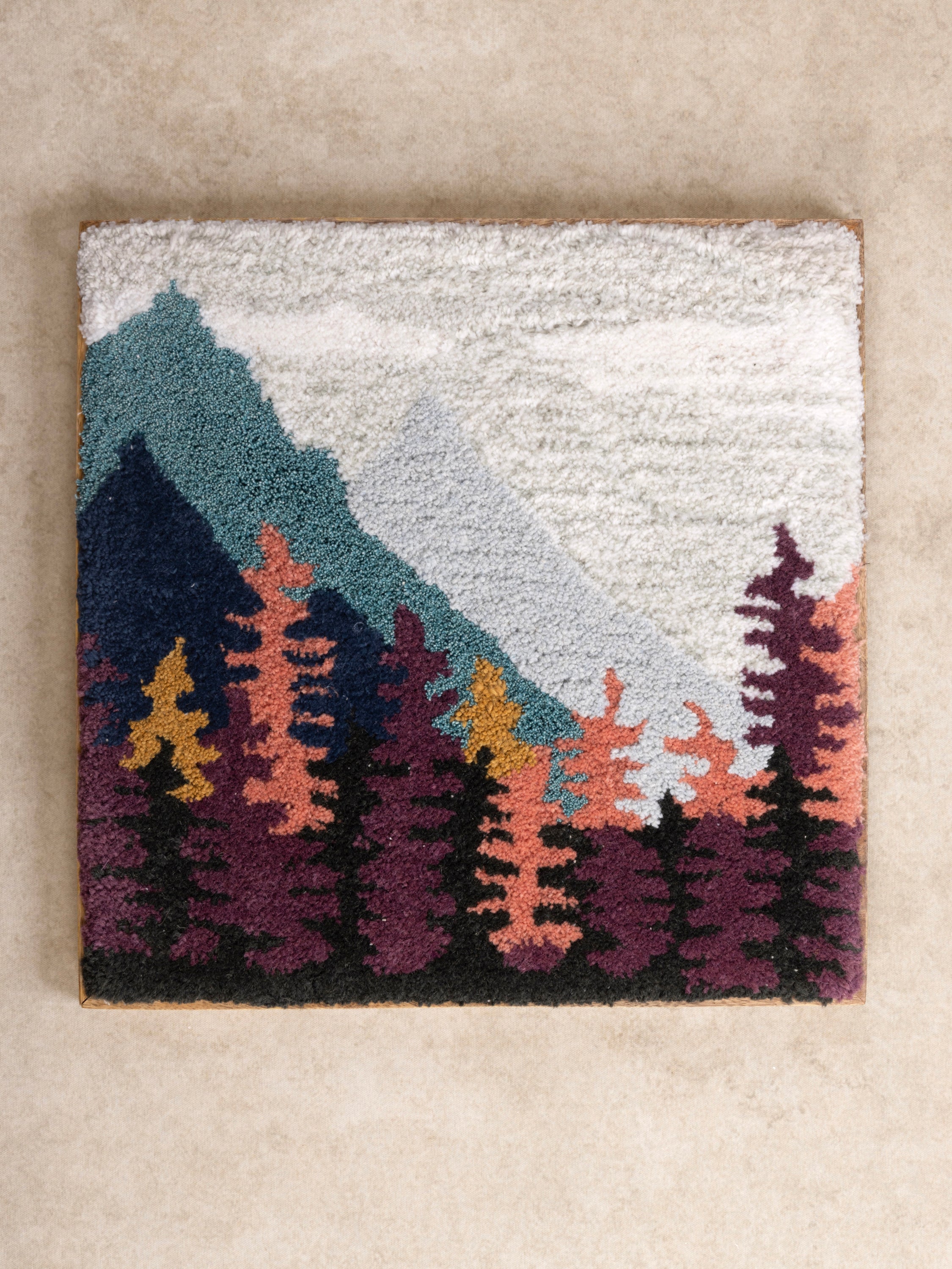 Hand-Tufted Wall Art with Mountain & Forest Landscape – A textured fiber art piece featuring a misty mountain scene with colorful evergreen trees, adding warmth and depth to any space
