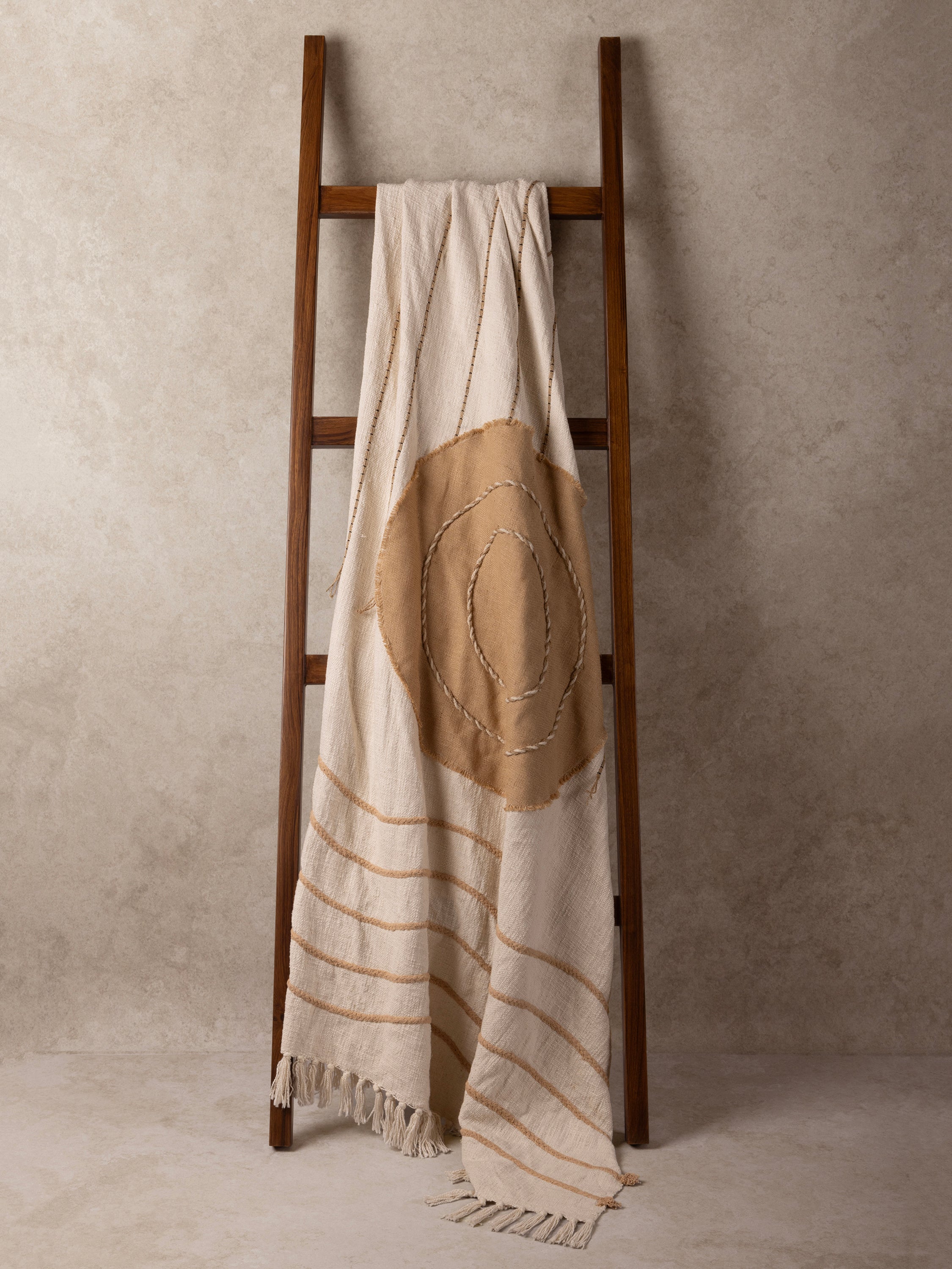 Handwoven Neutral Throw Blanket with Abstract Sun Design – A cozy, artisanal textile with earthy beige embroidery, evoking a peaceful, modern aesthetic