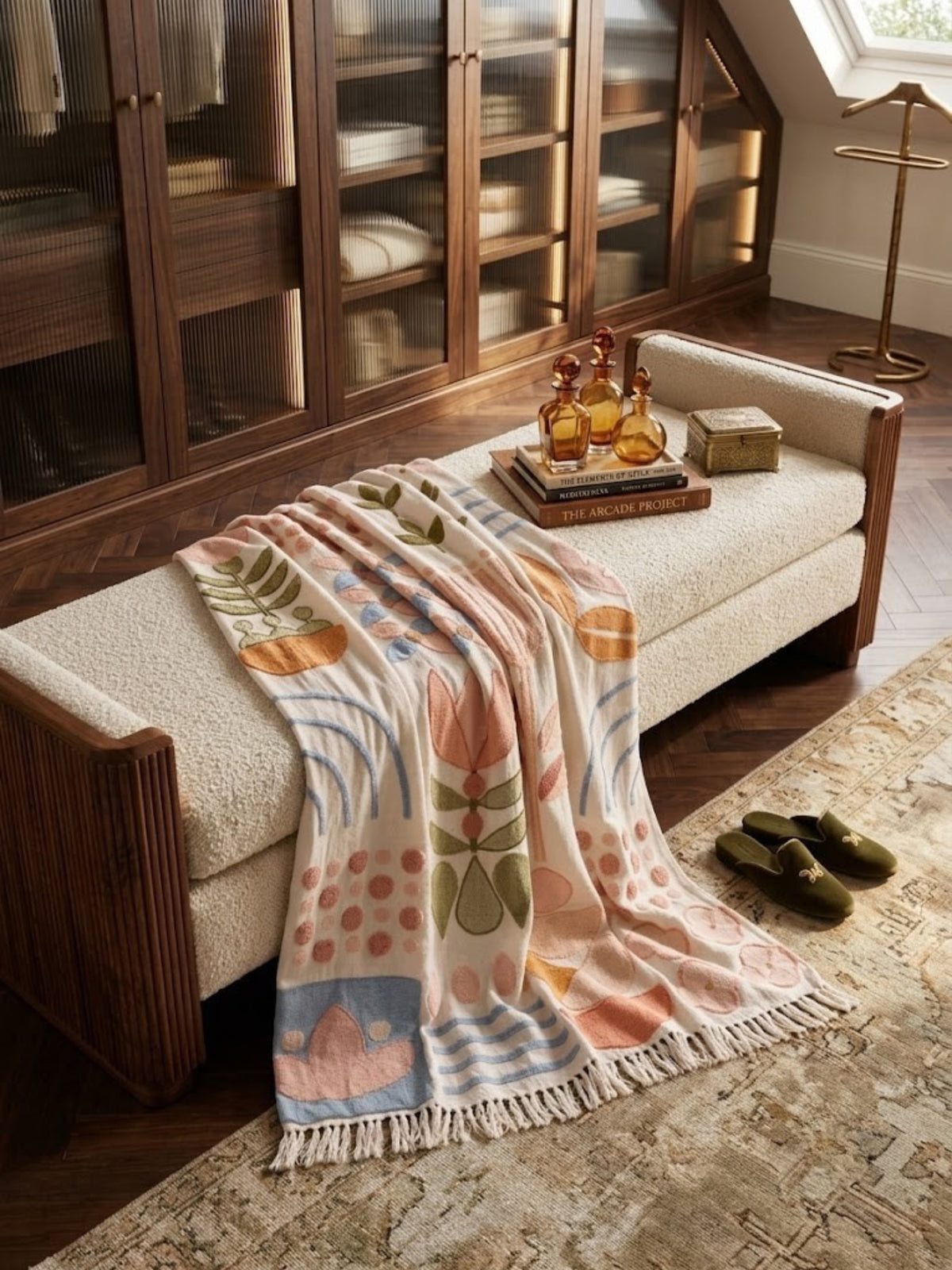 Joel ivory cotton throw with oversized tufted botanicals, laid over an upholstered bench.