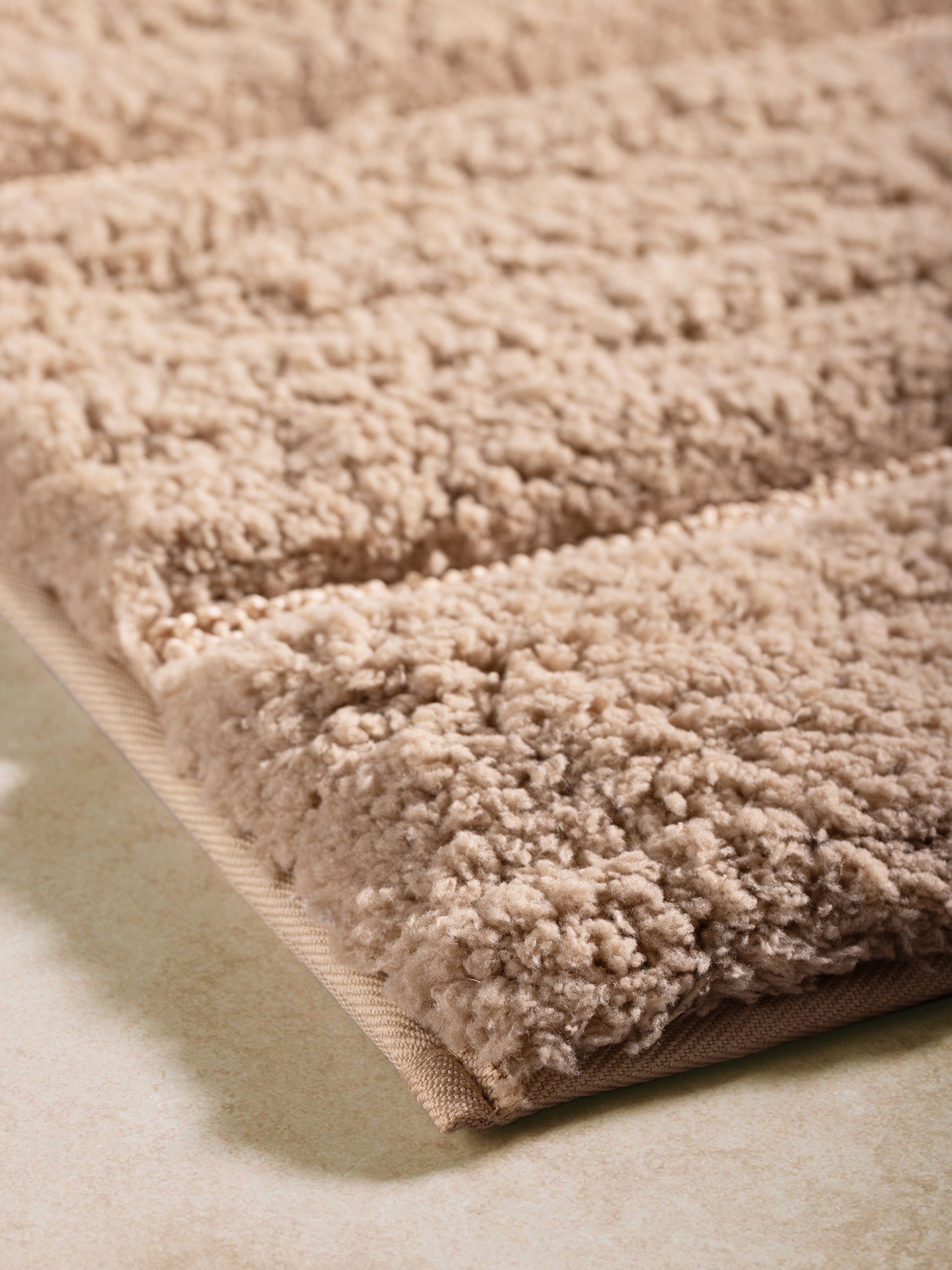 High-quality taupe bath mat with a non-slip backing for safety and stability