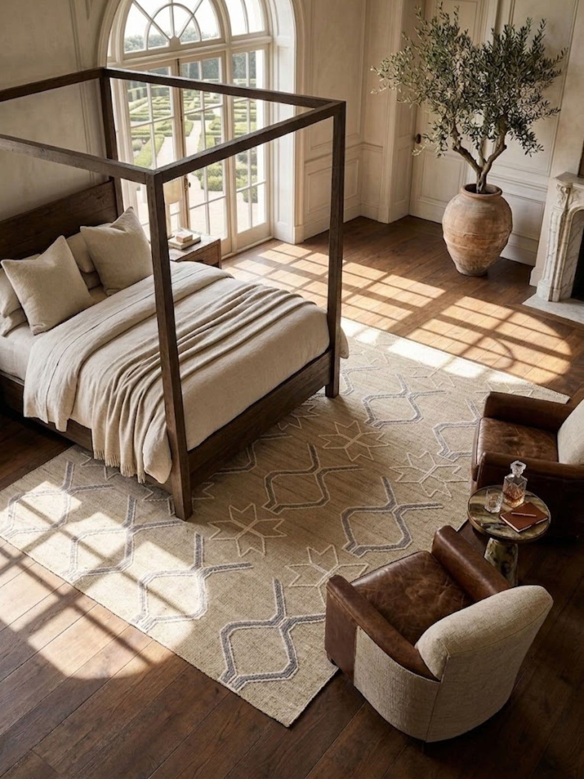 Wool rug with cream and grey-blue geometric motifs, layered beneath a canopy bed.