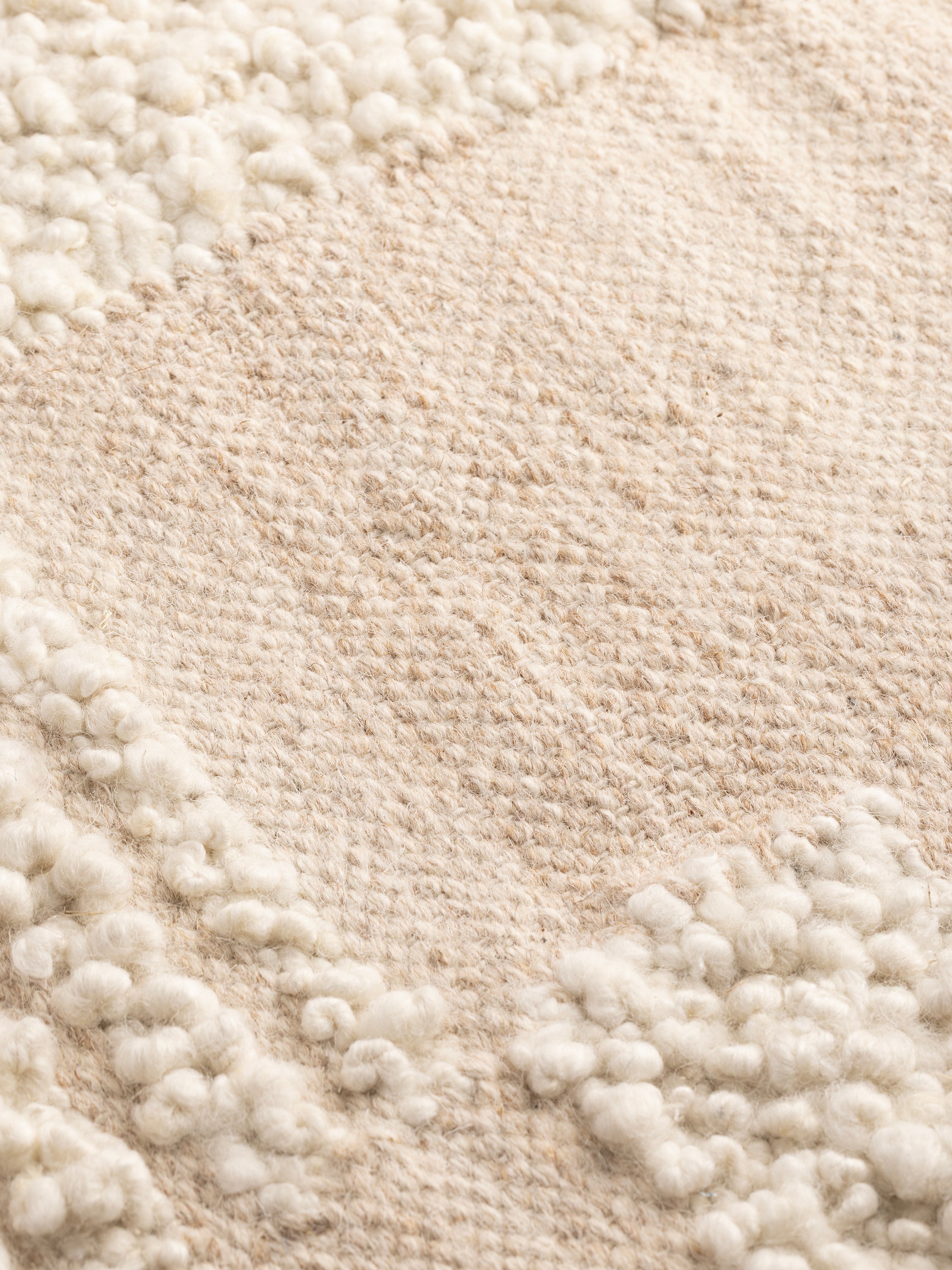Close-up of Minerva rug showing mixed weaves, looped details, and premium natural fibers