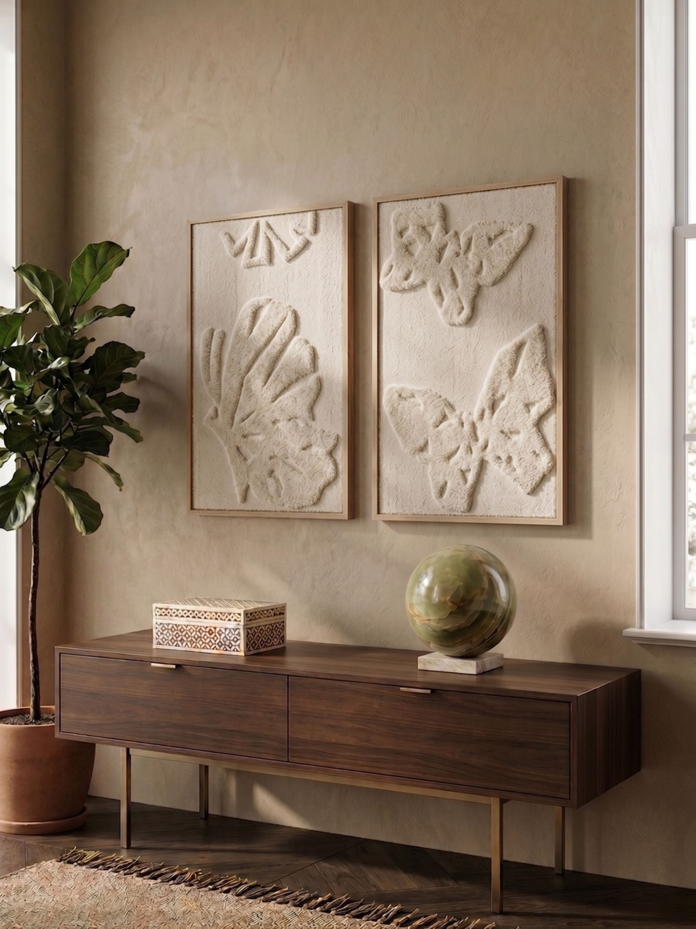 Set of two tufted wool wall art panels with raised botanical motifs in soft ivory tones, displayed above a wooden console in a warm neutral interior