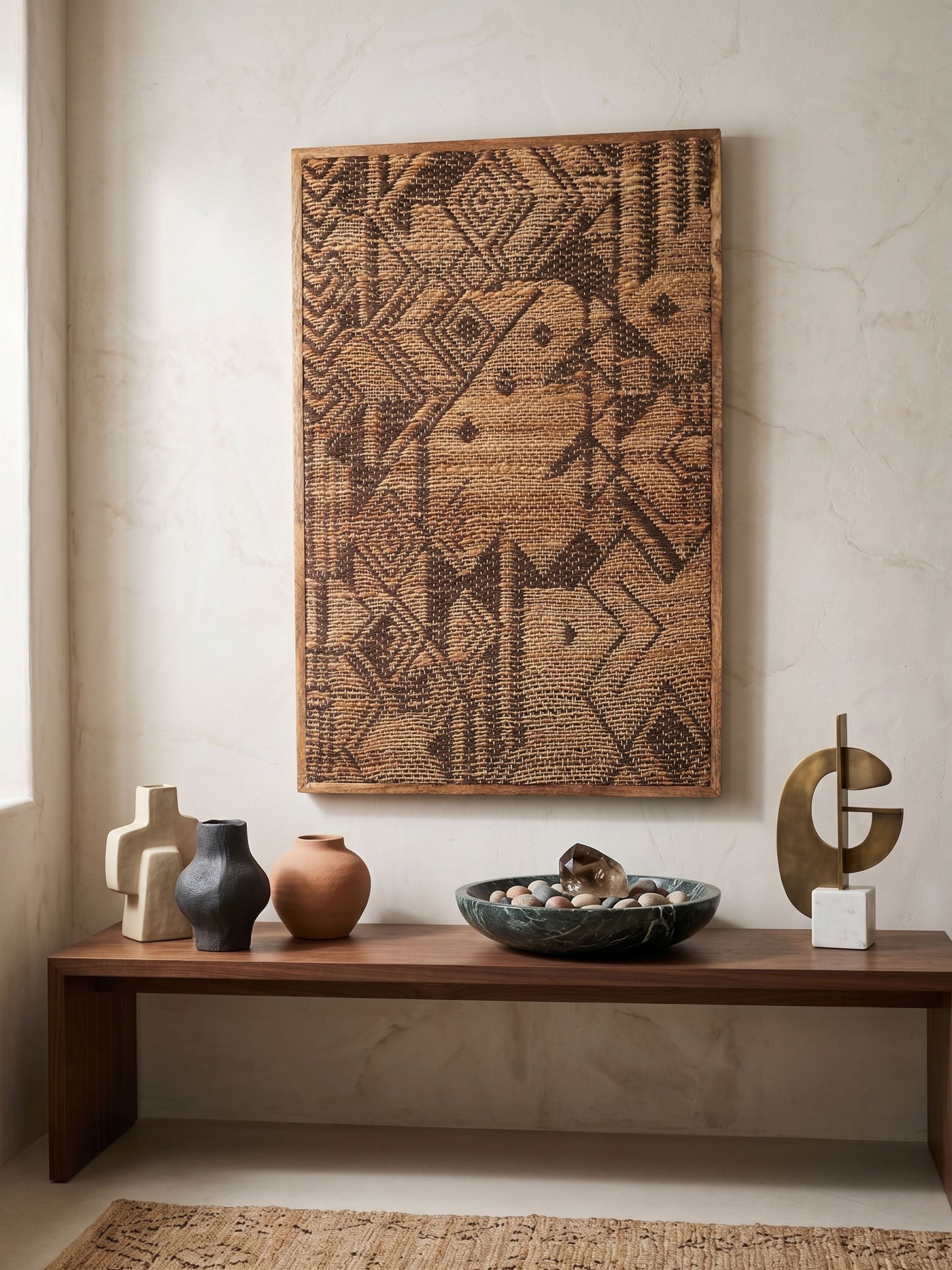 Jacquard woven jute wall art with geometric pattern in natural brown tones, framed in wood and placed above a wooden console with minimal decor