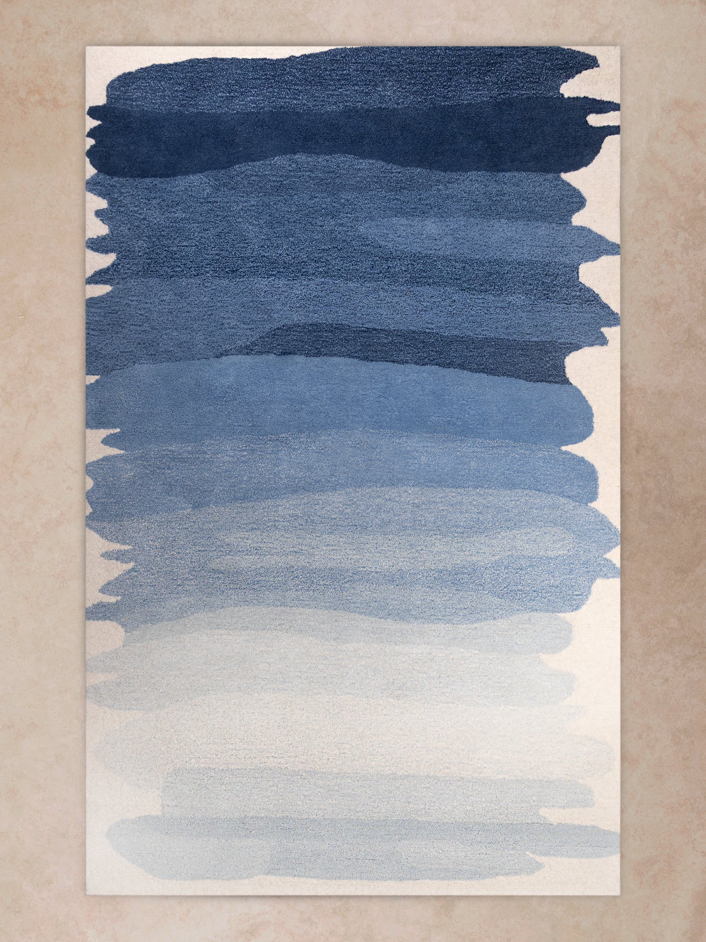 Handwoven area rug with layered blue gradient transitioning into soft ivory tones, shown in motion with shifting light revealing pile texture, tonal depth, and organic color transitions